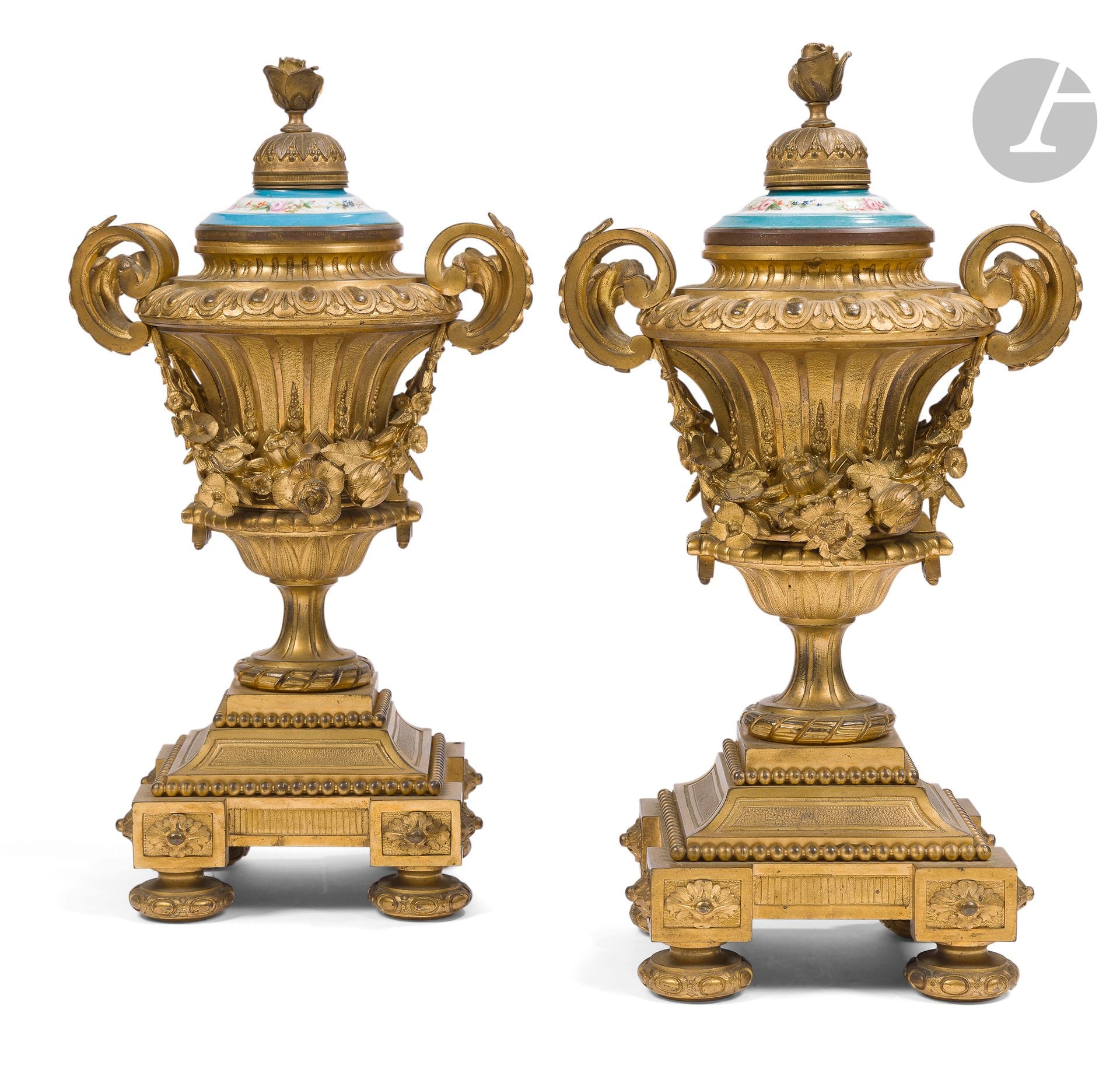 Paire de vases d'ornements en bronze doré et porcelaine, à décor de guirlandes de fleurs, perles et rubans, reposant sur une base à décrochements et pieds circulaires ; (usures à la porcelaine).
De goût Louis XVI, seconde moitié du XIXe siècle.
H : 45 cm