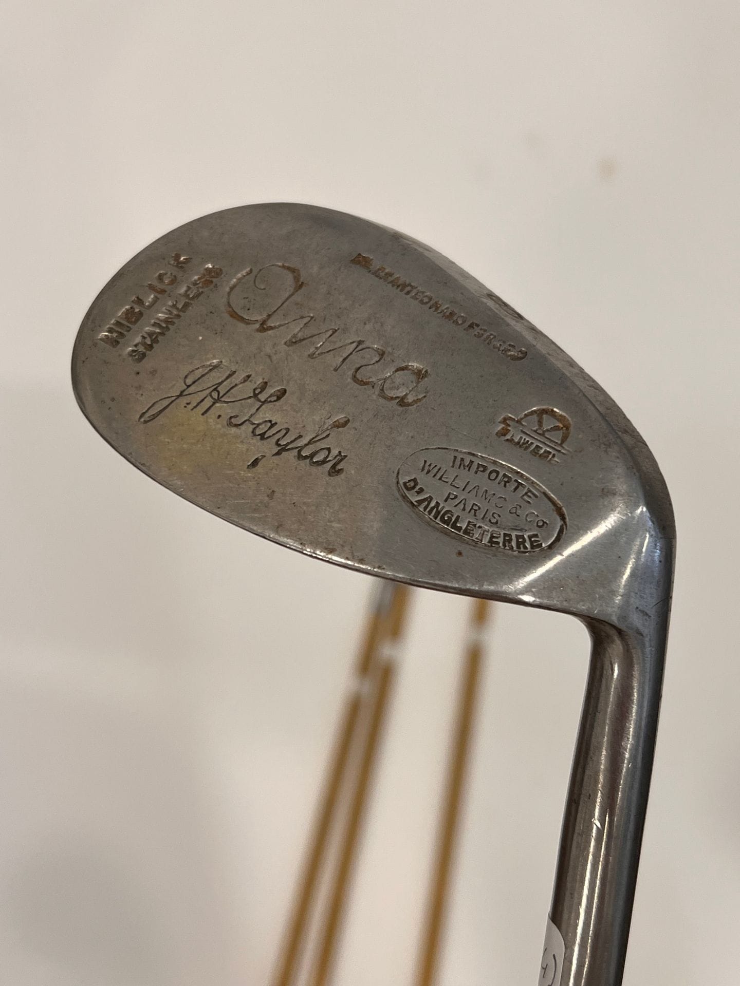Suite de quatre fers: Iron 2, mashie, mashie niblick et niblick, J. H. TAYLOR. importé d Angleterre par Williams & Co Paris. marque à la roue. Marqués Anna . Manches en acier façon bambou, grips Taylor anciens en cuir prune, marqués. Circa 1930.