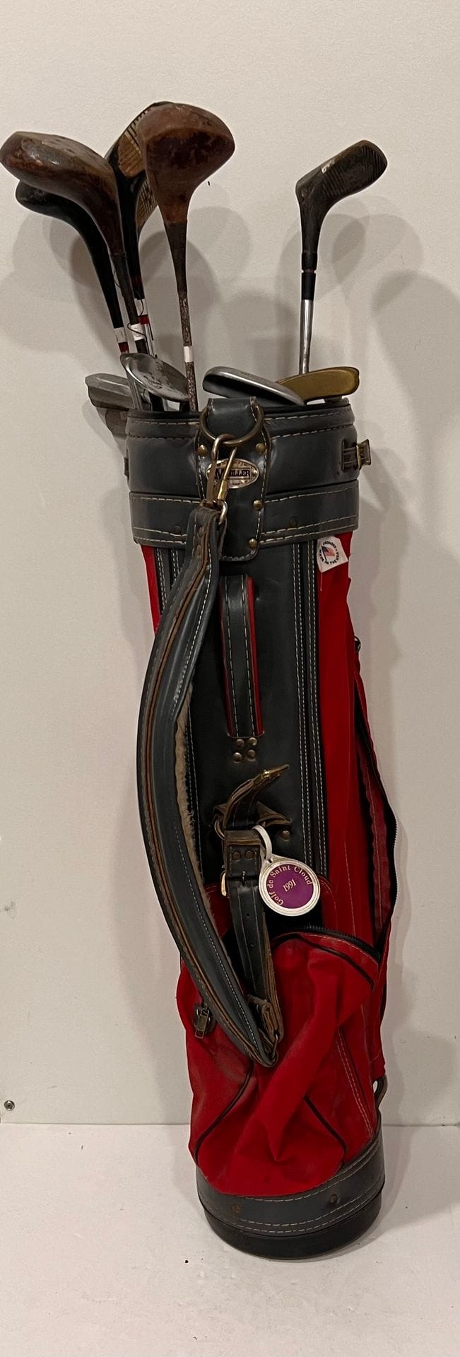 1950s burgundy leather golf bag containing a set of seven A.G. SPALDING &amp; BROTHERS clubs. SPALDING &amp; BROTHERS, made in the U.S.A., with arrow markings in the target: 2, 3, 4, 5, 7 &amp; 9 irons, and putter, Symetric Irons model. The sweetspot is marked p. (N°275) N°14