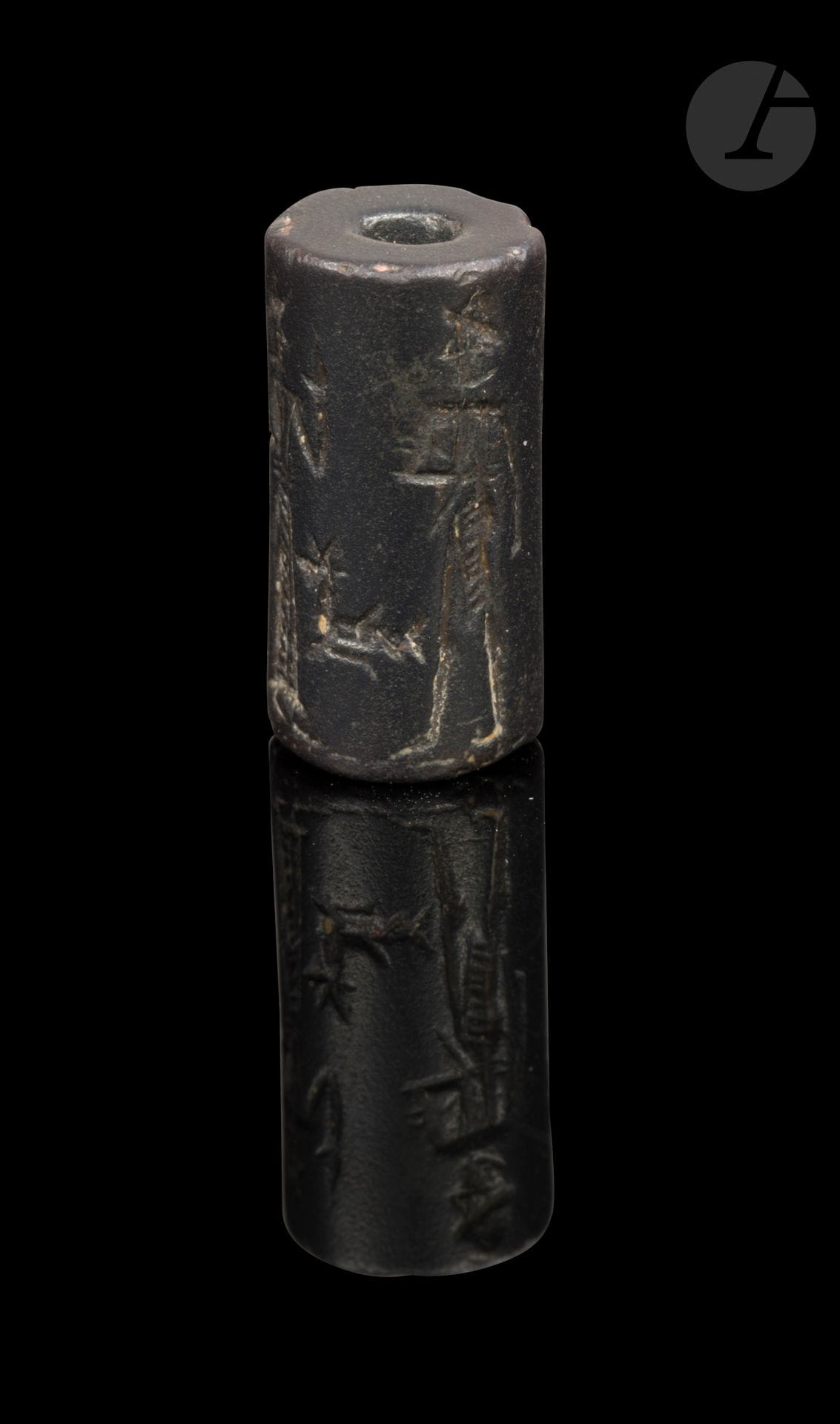 Cylinder seal featuring a turbaned figure wearing a fringed shawl, holding a weapon in his left hand.
Opposite him, a figure wearing a truncated cone-shaped hat, raising his right arm. Behind the first figure, a goddess intercedes. 
Hematite.
Sumerian art, Paleo-Babylonian period (1763 - 1595 B.C.).
Height: 2 cm 

Provenance : 
From a copy of the collectors' notes, acquired from Hindamian in 1952.

Publication: 
DANMAVILLE, Jenny, "La Collection Thierry", Revue d'Assyriologie et d'archéologie orientale, 1965, vol. 59, p. 59, reproduced fig. 18. Indicated as "purchased from a Paris antique dealer as coming from Baghdad".

Collection Nicole et Jean-Michel Thierry - lots 1 to 141.