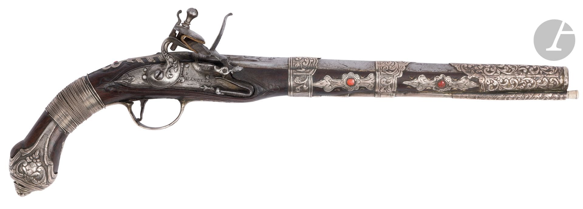 Flintlock pistol, Ottoman Algeria, 19th century 
Round steel barrel engraved with vegetal scrolls and a name in Latin capitals. Flintlock lock signed "S. Scandela" and engraved with foliage repeated on the hammer. Silver fittings with engraved and embossed plant decoration, some hallmarked, some enhanced with a coral cabochon. Wooden stock inlaid with silver fillets and finished with a silver cap. Wooden ramrod with bone tip.
Length: 47.5 cm; gross weight: 932 g 
A few chips of gilding.