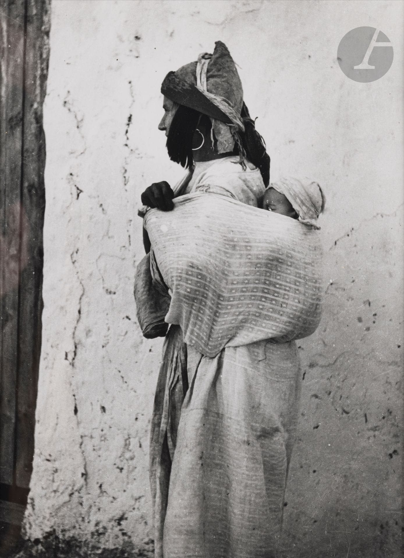 Jean Besancenot (1902-1992) 
Morocco, 1934-1939. 
Middle Atlas. Jewish woman in Midelt wearing the bniqua hairstyle. Document collected in Midelt, where Jewish women wear the same hairstyle as the women of Fez. Document from Midelt - Wearing riouch, goat hair guiches. 
Three (3) silver prints (c. 1980), matted, signed in pencil on the mounts lower right. Handwritten captions and negative numbers in pencil inside the mounts below. 
Medium format: 24 x 18 cm