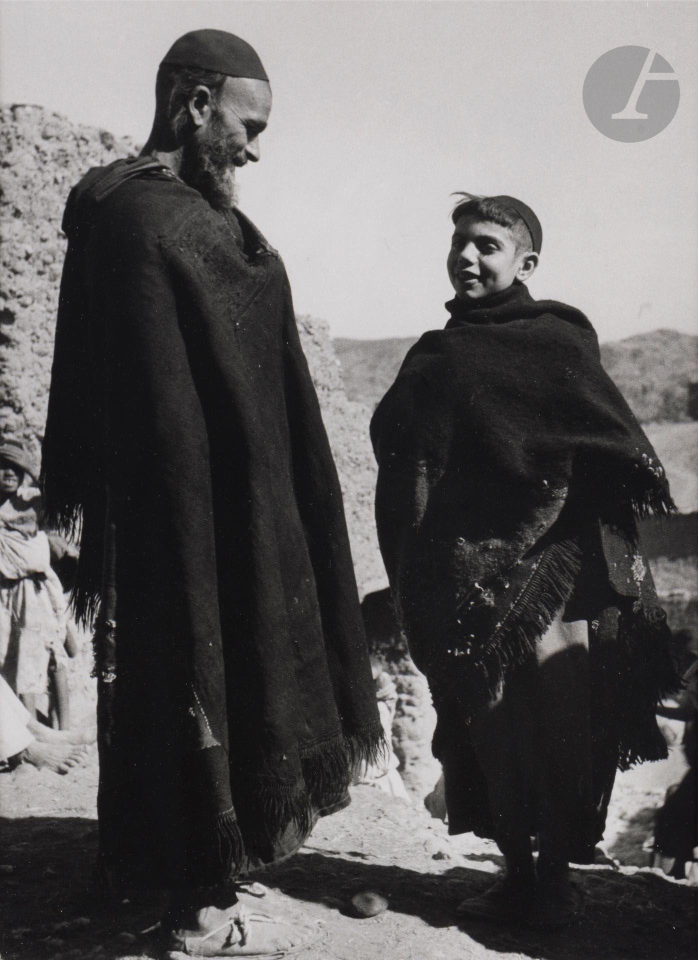 Jean Besancenot (1902-1992) 
Morocco, 1934-1939. 
High Atlas. Ouarzazate, adornment of the wife of a great Berber chief wearing a set of city gold jewelry. Ouaouzguit country, south of Ouarzazate - The bow loom for weaving belts. Tikirt, Pays Ouaouzguit, south of Ouarzazate - Jewish man wearing the akhnif coat inside out - Young man wearing the akhnif thrown over his shoulder. 
Three (3) silver prints (c. 1980), matted, signed in pencil on the mounts lower right. Handwritten captions and negative numbers in pencil inside the mounts below. 
Medium format: 24 x 18 cm