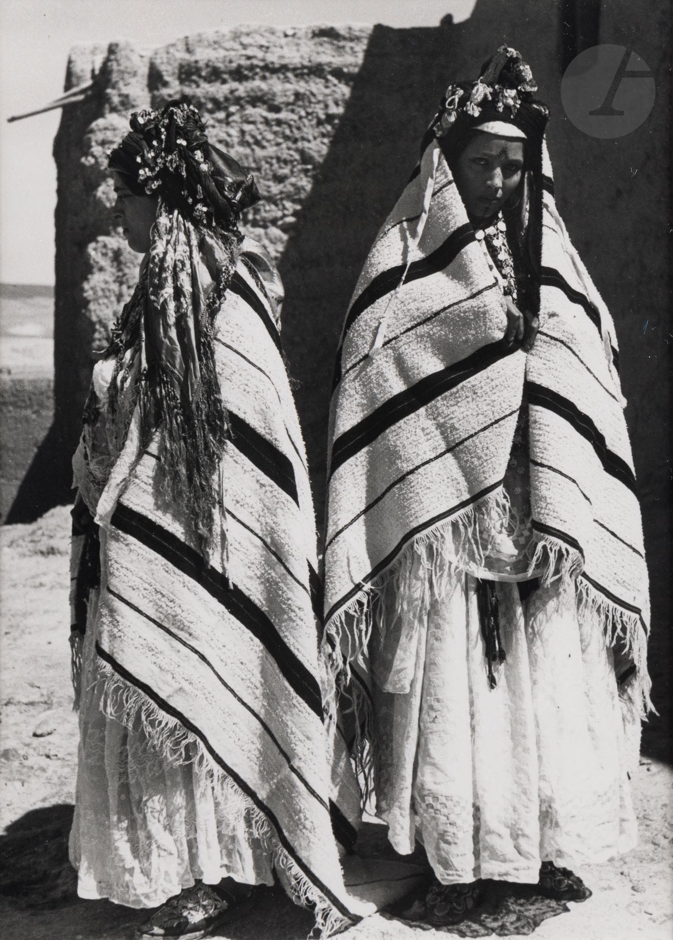 Jean Besancenot (1902-1992) 
Maroc, 1934-1939. 
Haut Atlas. En pays Mgouna, scène d’apprivoisement d’une fillette juive dont le costume est analogue, parure comprise, à celui d’une grande personne. Vallée de Bou Malem, ici port du diadème régional. Deux femmes berbères des Aït Izdeg - A gauche la couverture de laine sur les épaules - A droite portée sur la tête. Vallée du Dadès, deux femmes juives. 
Quatre (4) épreuves argentiques (c. 1980), montées sous passe-partout, signées au crayon sur les montages en bas à droite. Légendes manuscrites et numéros de négatif au crayon à l’intérieur des montages en bas. 
Format moyen : 24 x 18 cm
