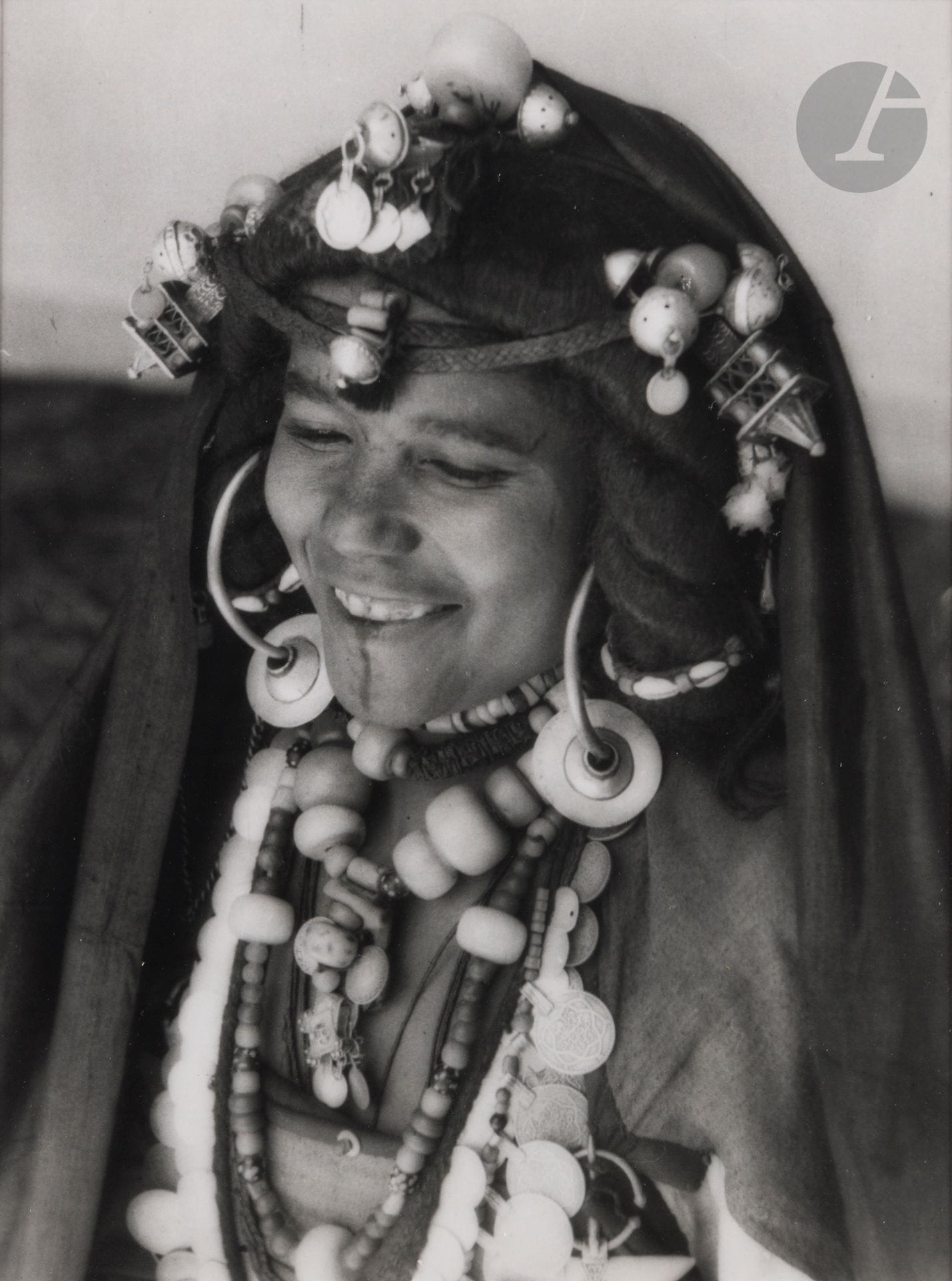 Jean Besancenot (1902-1992) 
Maroc, 1934-1939. 
Hartania des Ida ou Blal - À Agadir Tissint où la sompteuse parure traditionnelle est scrupuleusement conservée. Extrême-sud marocain, Tata - exemple de la richesse de la parure dans les populations des oasis présahariennes. Extrême-sud oriental, Bani - Coiffure et parure d’une hartania des Mribet. Confins sahariens, Bani - Femmes bleues des milet porteuses de cruches. 
Quatre (4) épreuves argentiques (c. 1980), montées sous passe-partout, signées au crayon sur les montages en bas à droite. Légendes manuscrites et numéros de négatif au crayon à l’intérieur des montages en bas. 
Format moyen : 24 x 18 cm