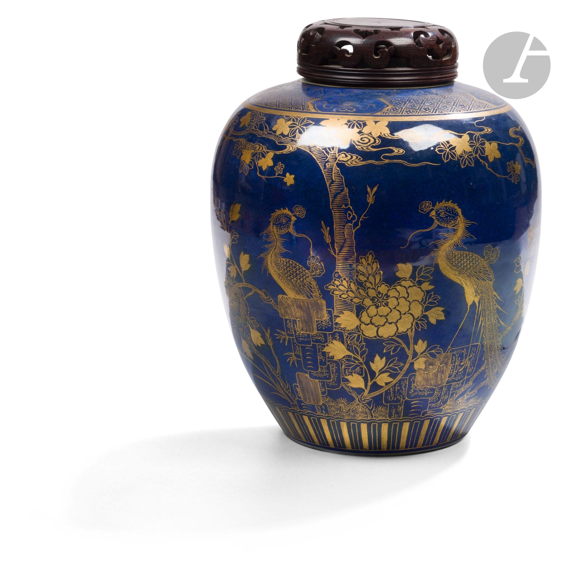 Pot à gingembre en porcelaine émaillée en bleu poudré et or d’un décor d’oiseaux, Chine, XIXe siècle
La panse à décor continu de deux petits oiseaux en vol et de deux fenghuang postés sous un arbre. Autour, des rochers et des branches fleuries de grandes pivoines. L’épaulement à décor d’une frise et de quatre cartouches renfermant des objets précieux pa pao : lingot, joyau et losange. Double cercle en bleu sous couverte à la base. Couvercle en bois ajouré.
Hauteur : 25 cm