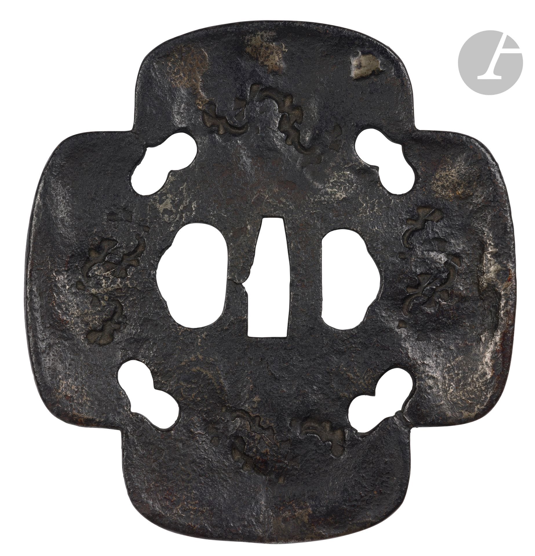 Grande tsuba en fer de forme kurikomi mokkô gata, Japon, début de l’époque Edo (1603-1868)
Dans cette forme kurikomi mokkô, chaque angle intérieur est orné d’un inome (œil de sanglier) en sukashi. Le mimi est de type uchikaeshi (bords relevés à la forge), fortement martelé dans le style tembo avec utilisation de kokuin (tampons à chaud) et incrustations de laiton. Les tampons à chaud imitent les trous de vers du bois. Les diverses techniques utilisées dans la fabrication de cette tsuba sont caractéristiques de l’école Saotome Tembo.
15,2 x 14,3 cm

Provenance :
Ancienne collection Nourhan Manoukian (1906-1993). Par descendance.