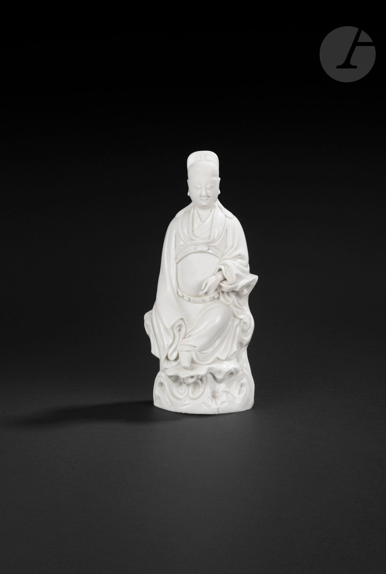Chinese white porcelain Wenchang, China, Dehua, 17th century
The Taoist god of literature is depicted seated on a pierced rock, wearing a long belted robe and an official's headdress. The face is serene, pierced with small holes for a moustache and beard. The right arm rests on a rock, revealing the hand, while the left arm is entirely concealed in the sleeve. 
Height: 33.5 cm

Provenance: 
Michael B. Weisbrod INC, New-York" label.