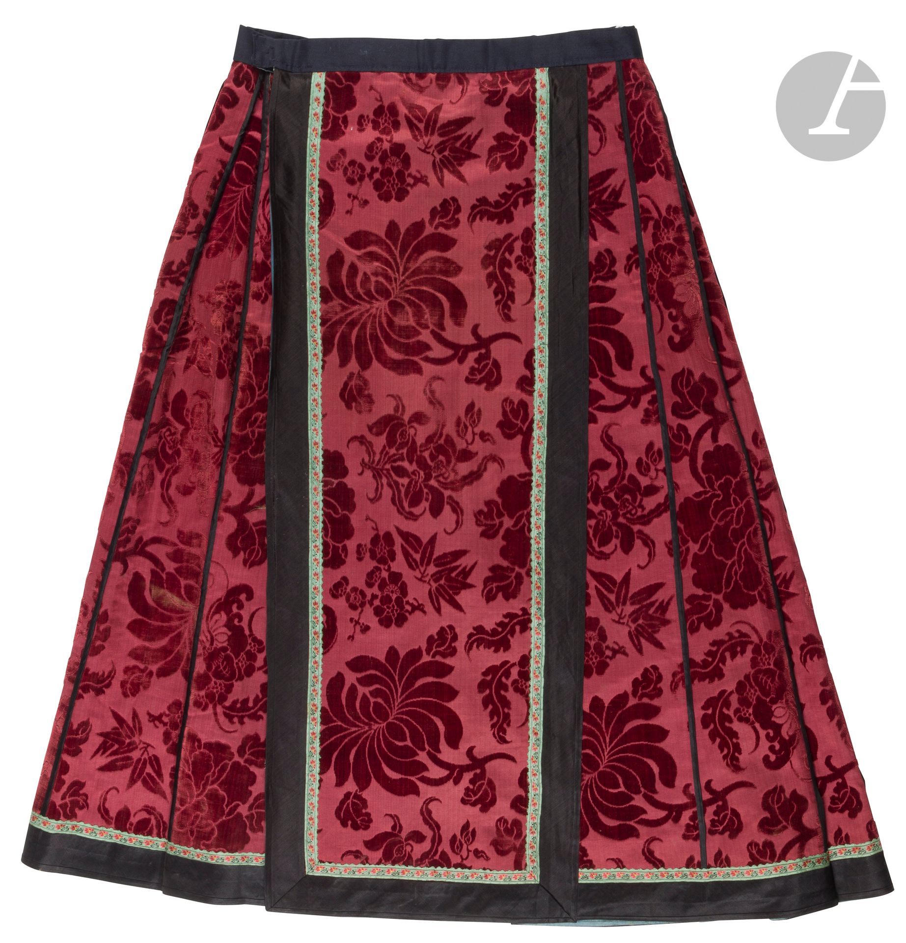 Women's māmiànqún skirt in garnet-colored silk embroidered with flowers, China, late 19th - early 20th century
In damask crepe with taffeta background, decorated with peonies, bamboo, plum blossoms, butterflies and orchids. The main panel is surrounded by a light blue braid embroidered with small polychrome flowers. Blue satin lining. 
Height: approx. 87 cm
Original ecru cotton canvas belt missing.