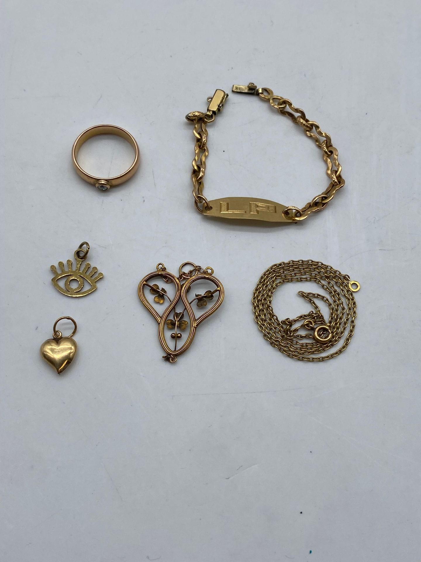Lot en or comprenant : 
Une bague en or 750/°°° sertie d'un brillant, poids brut : 3.9 g.
Une gourmette monogrammée LP en or 750/°°°, la chaine en plaqué or, poids brut : 3.4 g.
un pendentif en forme de coeur en or 585/°°°, poids net : 0.4 g
un pendentif à décor de trèfles orné d'une pierre rouge en or 750/°°°, poids brut : 1.2 g. 

Poids brut total : 8.9 g. 

on joint une pendentif en métal doré et une chaine en métal doré

Frais acheteurpiècesetlots enor: 9,6% TTC-8% HT