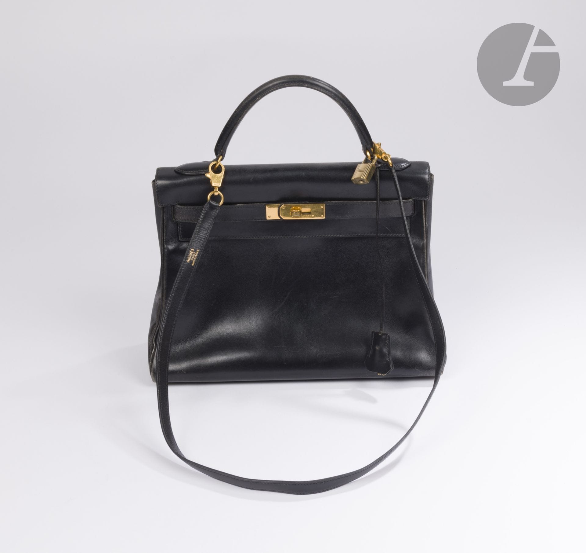 HERMES Paris Made in France
Sac Kelly 32 retourné en box noir, garniture en métal doré, bandoulière, cadenas et ses deux clés sous clochette. 31 x 23 x 12 cm. Dans sa housse
Année 1994
(usures aux angles, couture du sanglon gauche à revoir, quelques griffures et traces, housse déchirée)