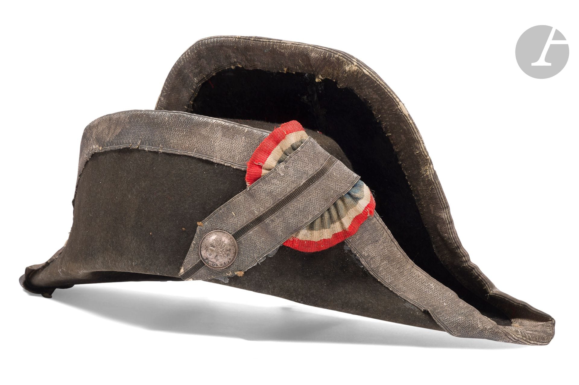 Bicorne de gendarmerie. 
En feutre taupé. Bordure des ailes et ganse en galon argenté, à lézardes
Cocarde brodée tricolore. Coiffe intérieure avec cachet de réception de la gendarmerie. 
E.M.(Usures). IIIe République.