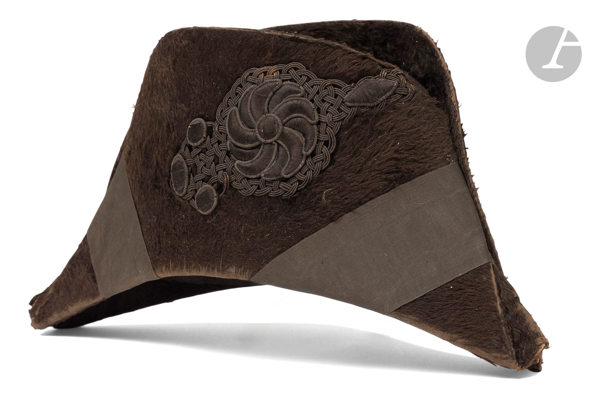 Rare demi-solde bicorne.
In black taupe felt, adorned with two braids and a flower motif embroidered on a woven background. Inner cap in fine scarlet cloth with black headband. 
A.B.E. circa 1820-1830.