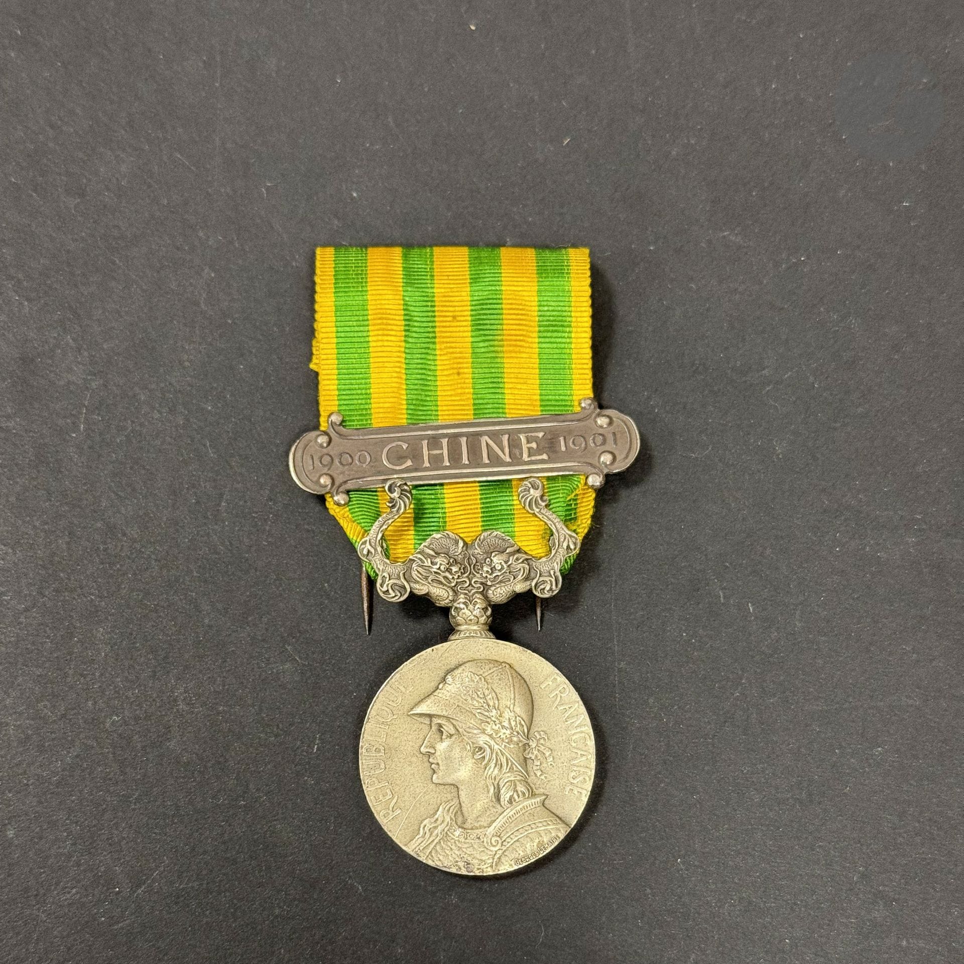 FRANCE 
MÉDAILLE DE CHINE (1900-1901) 
par Lemaire. En argent. Poinçon de la Monnaie sur la tranche. Ruban à agrafe en argent « 1900 – CHINE - 1901 ».
49 x 28 mm - Poids net : 22 g
T.T.B.