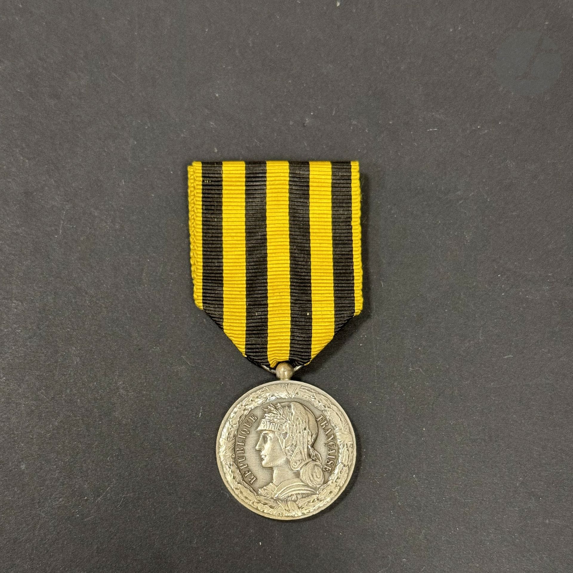 FRANCE 
MÉDAILLE DU DAHOMEY (1892)
Médaille par Dupuis. En argent, bélière boule. Poinçon de la Monnaie à la corne d’abondance. Ruban. 
29 mm - Poids net : 14 g 
T.T.B..