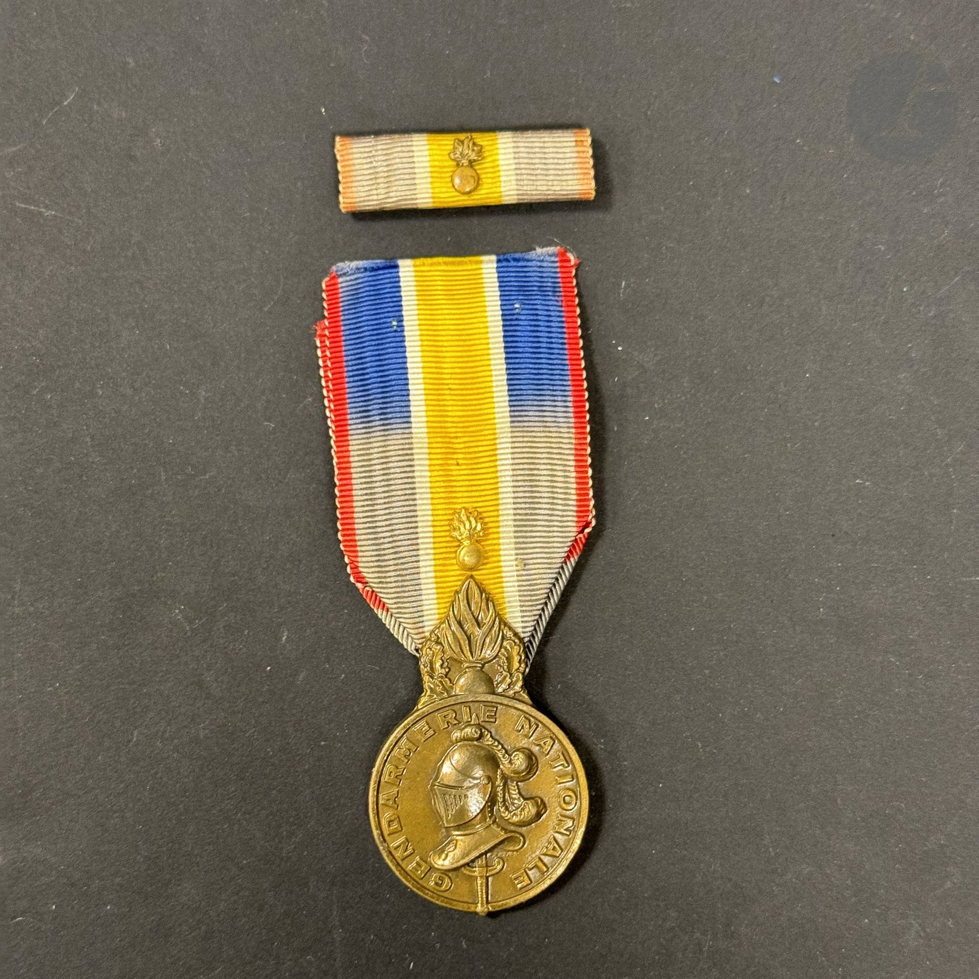 FRANCE 
MÉDAILLE D’HONNEUR DE LA GENDARMERIE 
En bronze, attribuée à P. GUELLE. Ruban à motif à la grenade. 
Avec rappel de décoration. 
T.T.B.