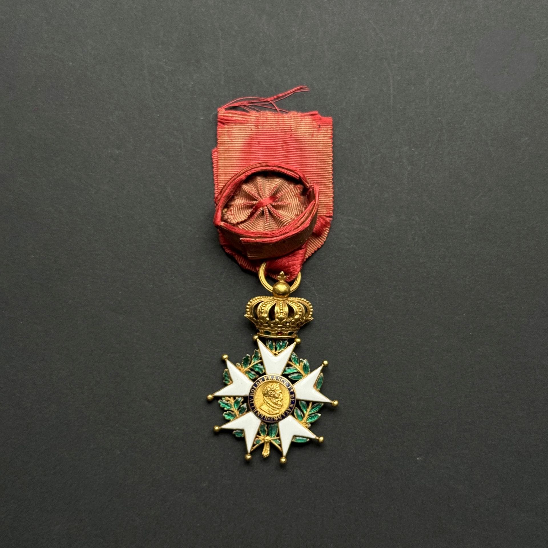 FRANCE 
ORDRE DE LA LÉGION D’HONNEUR 
Étoile d’officier d’époque Restauration. 
En or et émail. Anneau cannelé. Ruban rosette ovoïde (détachée). 
Poinçon tête de bélier et tête d’aigle. 
60 x 41 mm - Poids brut : 18,8 g
T.T.B. (une boule légèrement faussée).