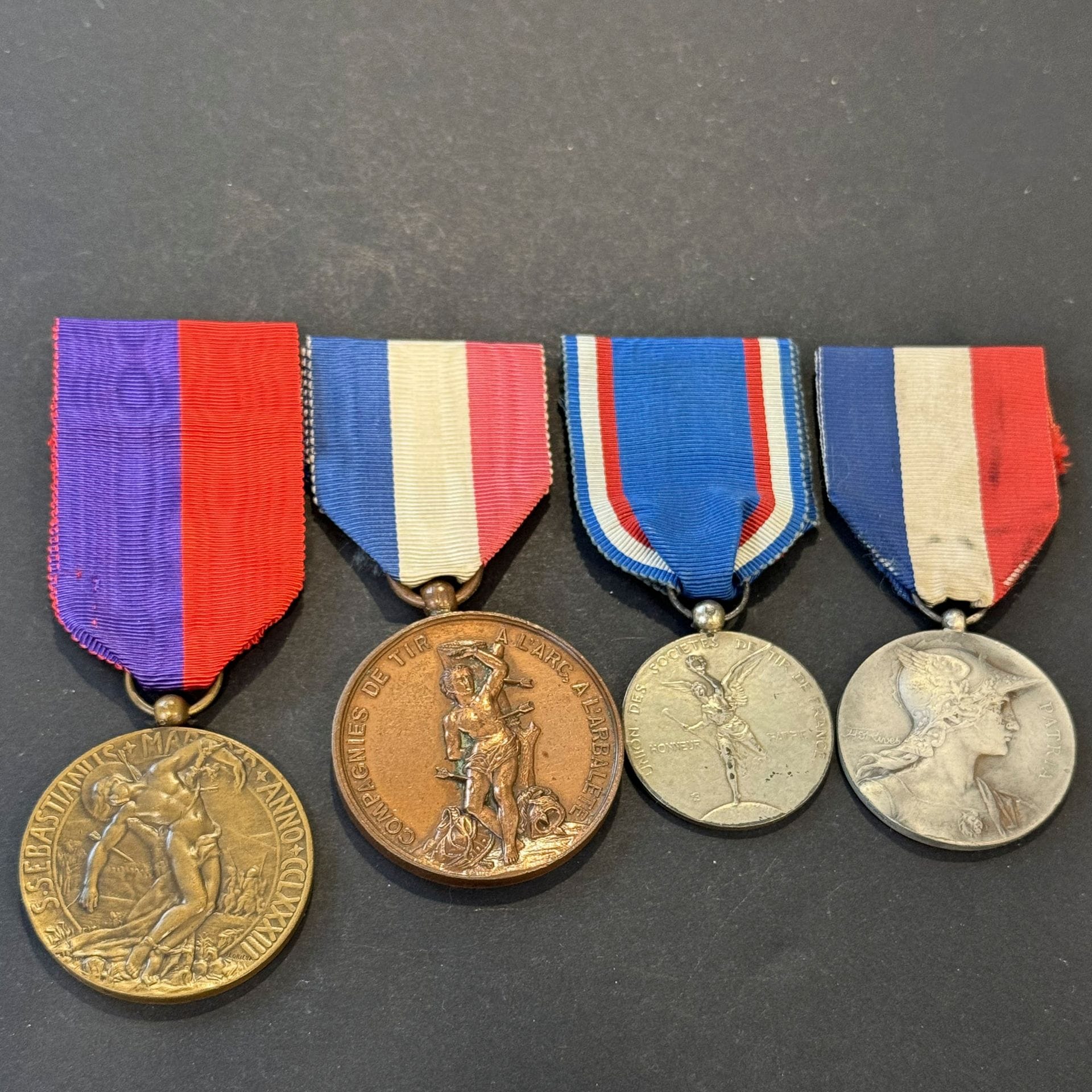 SOCIÉTÉ DE TIR 
Quatre médailles :
Médaille de la Fédération des sociétés de tir à l’arc de Roubaix, attribuée à Jean LECONTE pour 32 années de présence (1937), en bronze, médaille de société de tir en bronze argenté, poinçon de la Monnaie, médailles des compagnies de tir à l’arc, à l’arbalète, en bronze, médaille de l’union des sociétés de tir de France attribuée à N ALLARD, vétéran du tir (1896). 
Rubans.