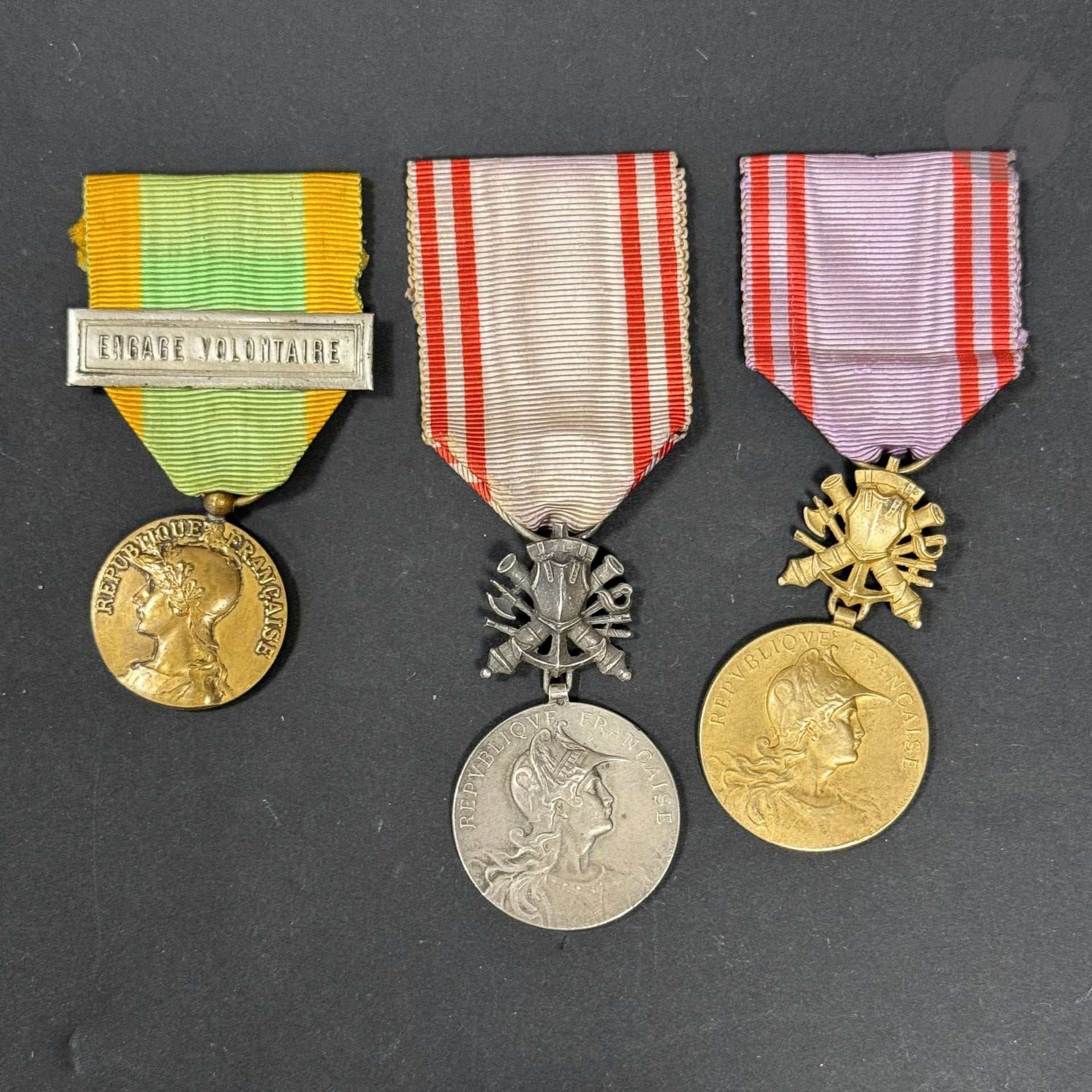 FRANCE 
MÉRITE NATIONAL - PRÉPARATION MILITAIRE 
Deux insignes : 
- Médaille d’or, en vermeil. Poinçon tête de sanglier. Poinçon d’orfèvre sur la tranche. Ruban. 
- Médaille d’argent, en argent. Poinçon tête de sanglier. Poinçon d’orfèvre sur la tranche. Ruban. 
55 x 30 mm 
On y joint une médaille d’engagé volontaire, modèle de Rivet non signé, en bronze. Ruban à agrafe « ENGAGE VOLONTAIRE » argentée.
T.T.B.