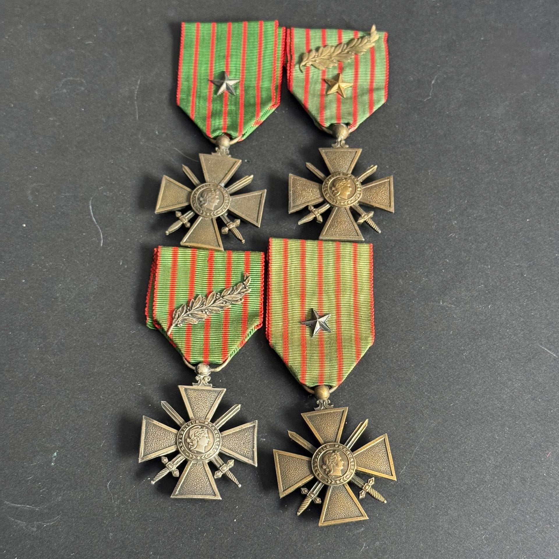 FRANCE 
CROIX DE GUERRE (1914-1918) 
Réunion de quatre croix de guerre 1re GM : 
- modèle en argent. Millésime 1914-1918. 
- en bronze. Millésime 1914-1918. Ruban à une étoile et une palme bronze. 
- en bronze. Millésime 1914-1916. Ruban à étoile argent. 
- en bronze. Millésime 1914-1915. Ruban à étoile argent.
T.T.B.