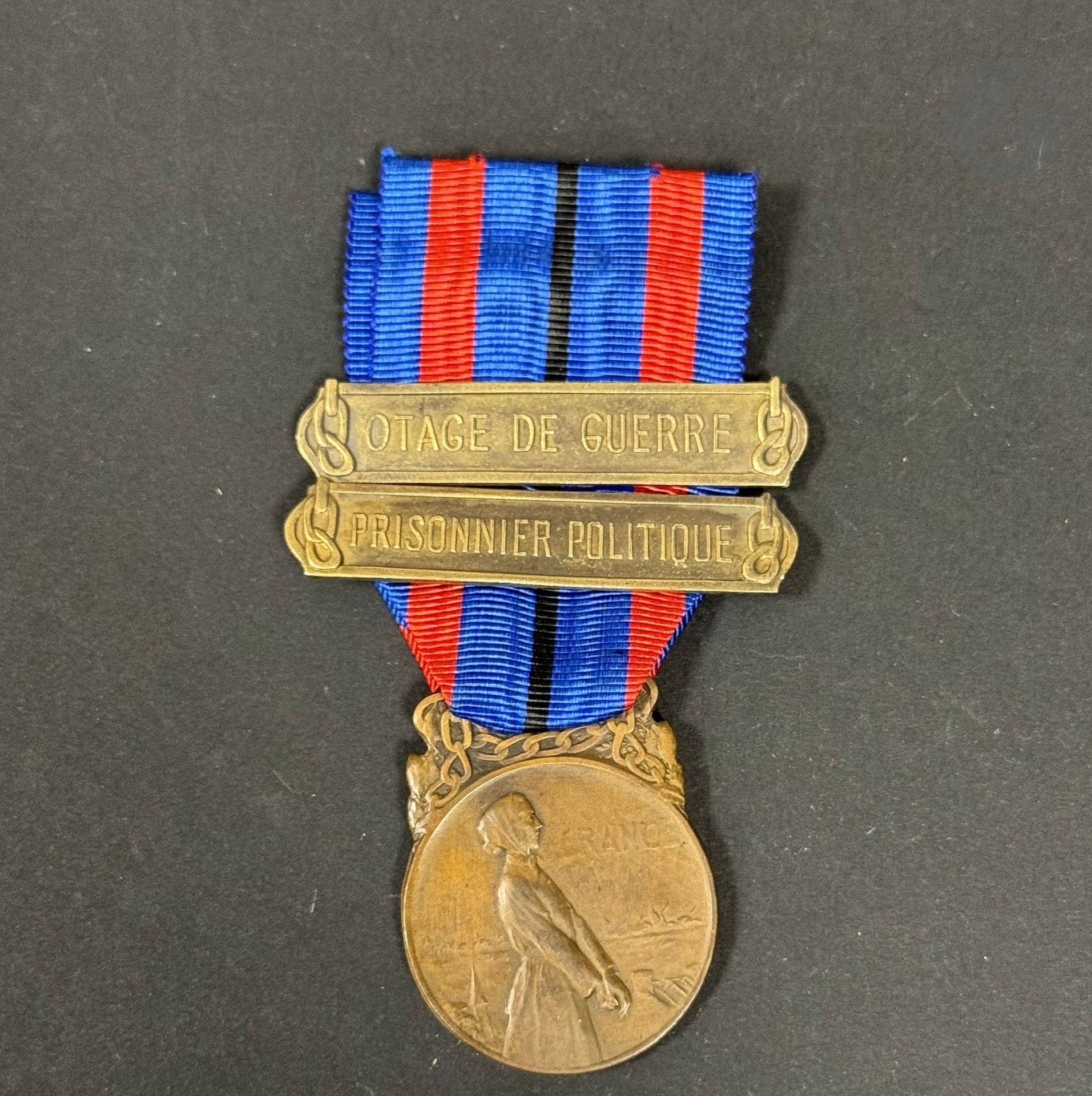 FRANCE 
Médaille « aux victimes de l’invasion » de 3e classe, degré « bronze » (1921). 
En bronze. Ruban à agrafes en métal bronzé « OTAGE DE GUERRE » et « PRISONNIER POLITIQUE ». 
39 x 28 mm
T.T.B.