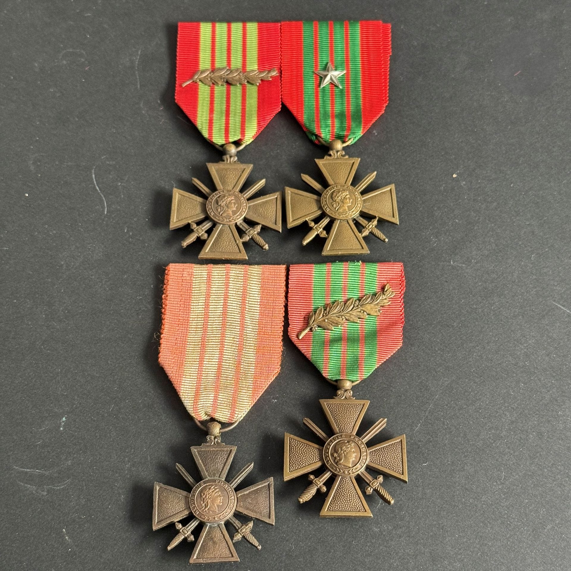 FRANCE 
CROIX DE GUERRE (1939-1945)
Ensemble de quatre croix de guerre 1939, dont un modèle dit « de Milan » 
En bronze. 
Rubans, dont un à étoile et deux à palmes. 
T.T.B.