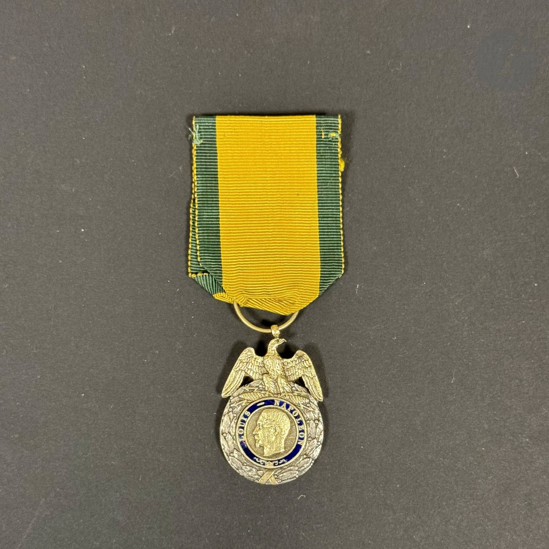 FRANCE 
MÉDAILLE MILITAIRE 
Médaille militaire du 1er type, modèle de la création. 
En argent, vermeil et émail (manques au revers, petite déformation de la bélière). Ruban ancien.
40 x 23 mm - Poids brut : 18,8 g
T.B. à T.T.B. Époque Second Empire.