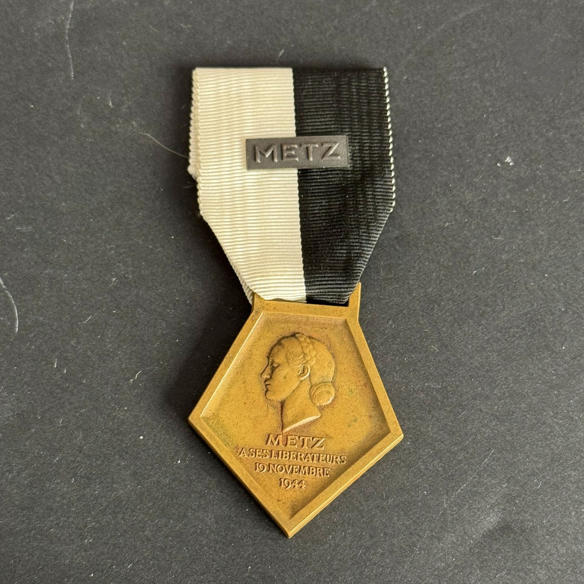 FRANCE 
Médaille de la libération de Metz (1944). 
En bronze, non poinçonnée. Ruban à petite agrafe « METZ ». 
42 x 37 mm
T.T.B.