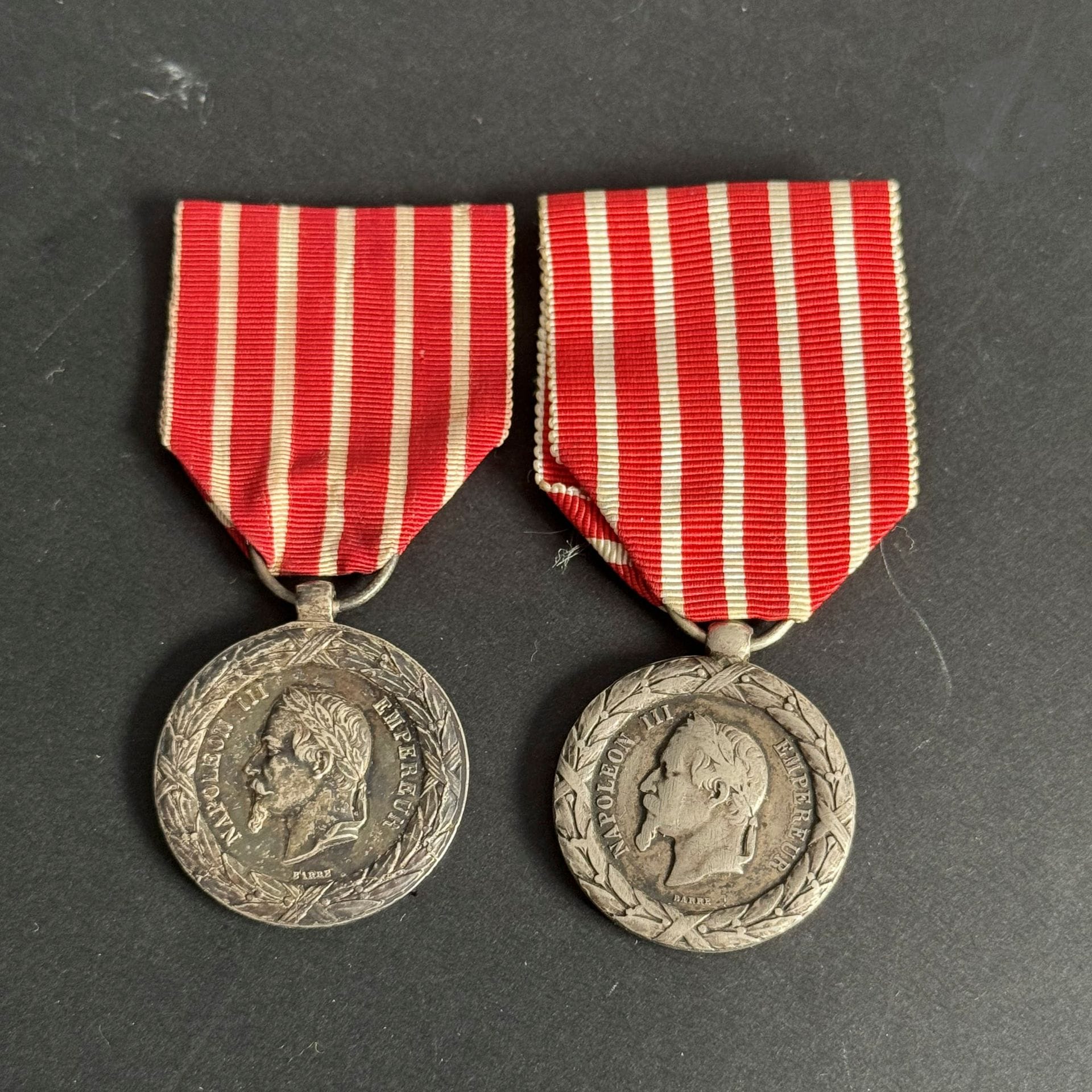 FRANCE 
MÉDAILLE DE LA CAMPAGNE D’ITALIE (1859)
Deux médailles de la Campagne d’Italie, 2e type, par Barre. 
En argent. 
- une à couronne en fort relief. Usures à l’avers. Bélière olive - Ruban postérieur. 28 mm
- Bélière tube - Ruban ancien. 30 mm
Non poinçonnées. 
T.T.B.