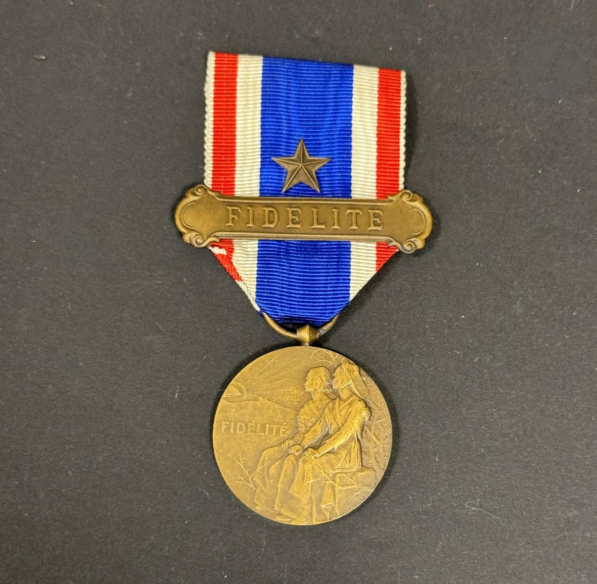 FRANCE 
MÉDAILLE DE LA FIDÉLITÉ FRANÇAISE 
- une médaille d’ordonnance. 
En bronze. Ruban à une étoile et agrafe en bronze « FIDELITE ». Bélière tronconique. Poinçon de la Monnaie sur la tranche 
30 mm
T.T.B. à SUP. 
- une réduction. 
En bronze. Bélière boule. Ruban à agrafe FIDELITE » 
13 mm
T.T.B. à SUP.