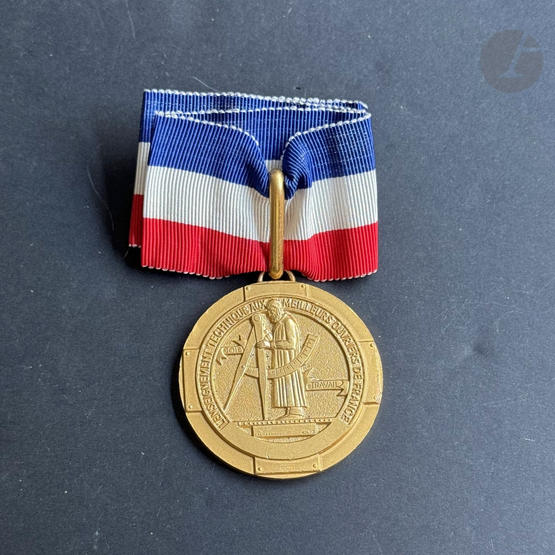 MEILLEUR OUVRIER DE FRANCE 
Insigne de meilleur ouvrier de France. 
En bronze doré, non émaillé, marqué « MONNAIE DE PARIS ». Cravate. 
Diamètre : 48 mm
T.T.B. (Petits usures sur la tranche)