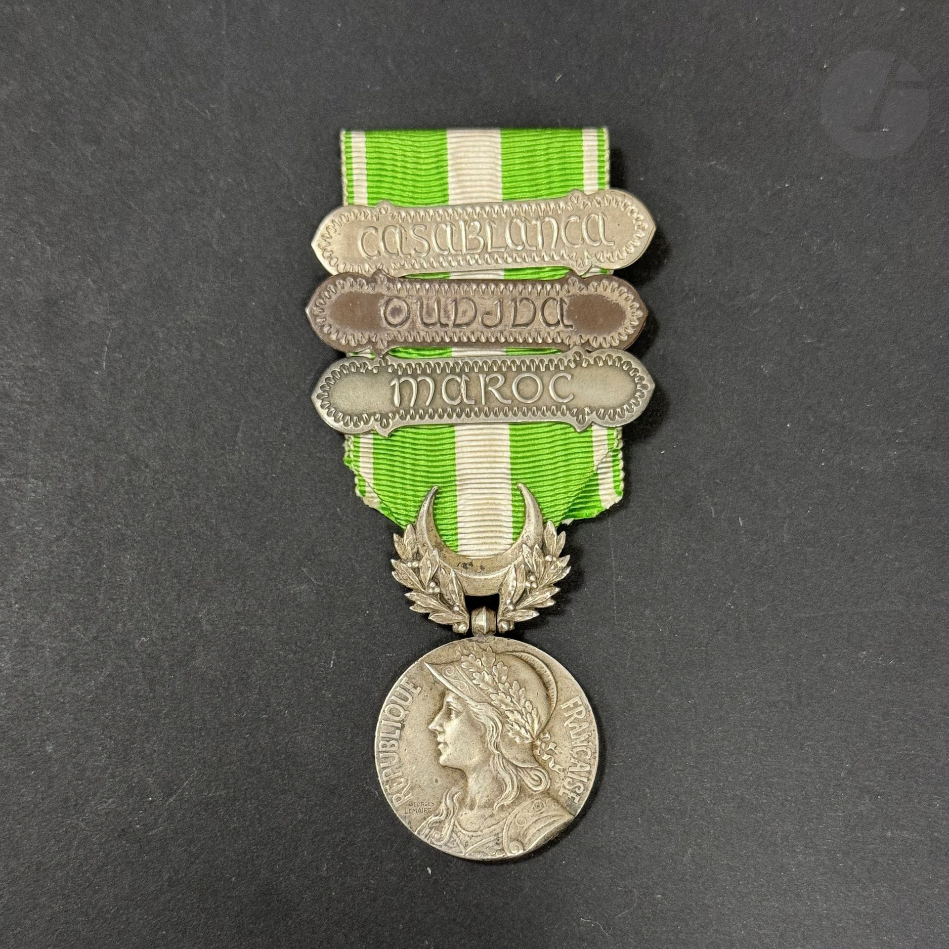 FRANCE 
MÉDAILLE DU MAROC (1909)
Médaille par Lemaire. En argent, poinçon de la Monnaie. Ruban à trois agrafes « MAROC », « CASABLANCA » et « OUDJDA ». 
48 x 28 mm - Poids brut : 25 g
T.T.B.