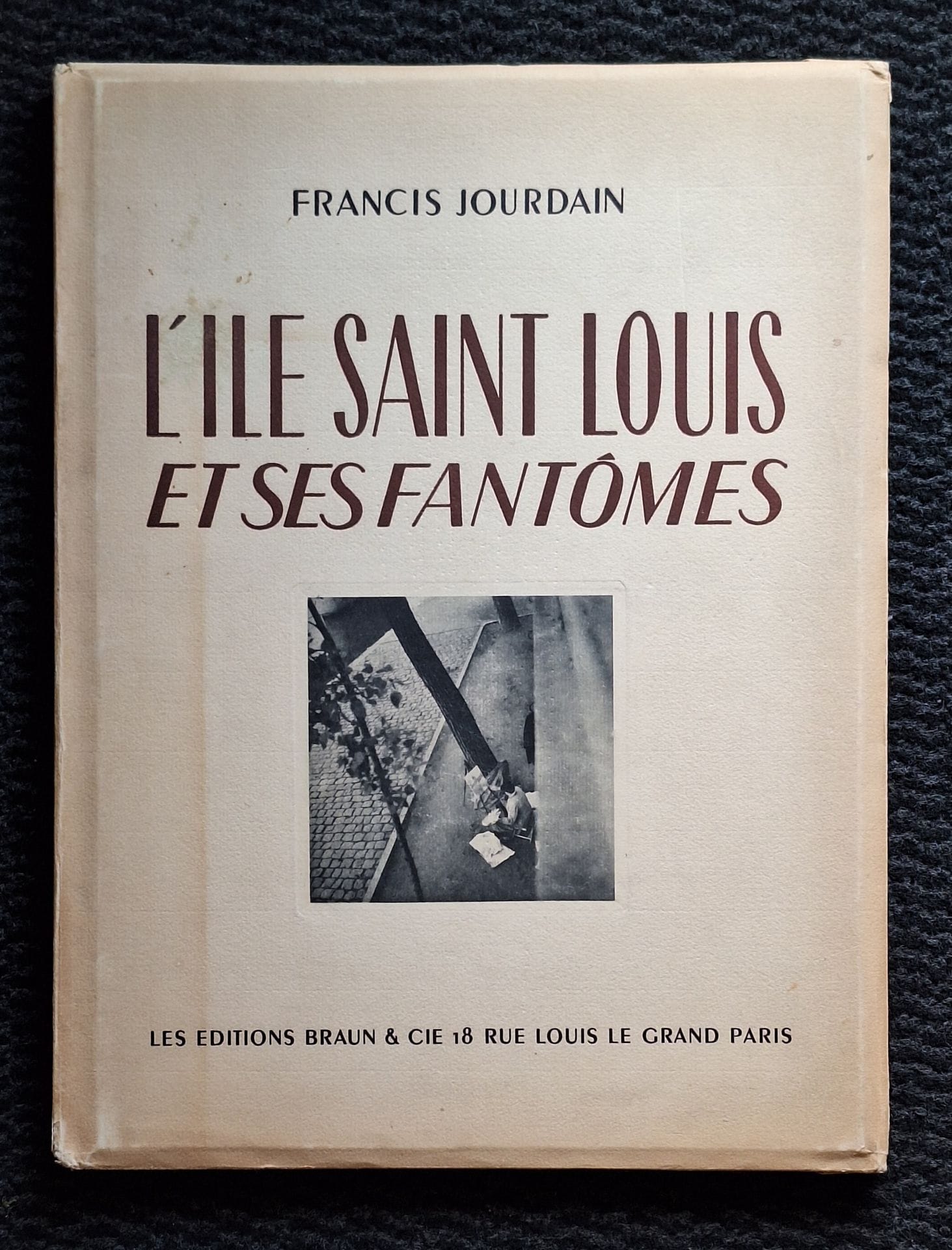 DUVAL, RÉMY (1907-1984)
L'Île Saint Louis et ses fantômes.
Les Éditions Braun & Cie, Paris, 1946.
In-folio (37 x 28 cm). Édition originale, tirée à 750 exemplaires numérotés. Exemplaire n°176. Texte de Francis Jourdain. Photographies de Rémy Duval. 20 pp. de texte, suivies de 15 photographies reproduites en héliogravure, encrées à la main à l'unité. Cartonnage rigide sous jaquette illustrée rempliée. Intérieur du livre en parfait état ; couverture légèrement brunie.
Rémy Duval a été l'assistant de Laure Albin-Guillot.