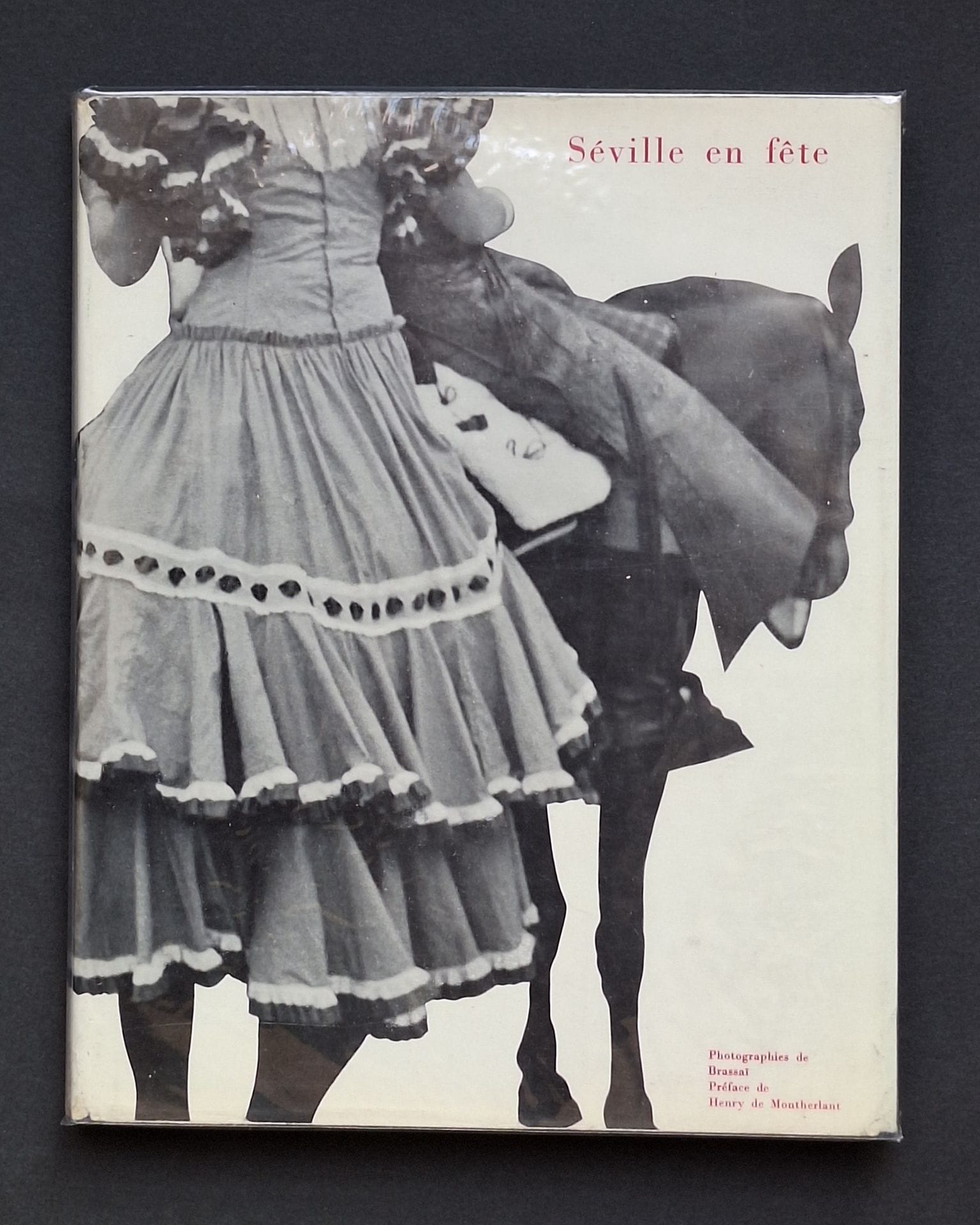 "BRASSAÏ (GYULA HALÀSZ, DIT) (1899-1984) [Signed]
Seville in Celebration.
Robert Delpire Éditeur, Collection Neuf, 1954.
In-4 (27.5 x 22cm). First edition, signed and dedicated by Brassaï to the American photographer Arnold Crane: "for Arnold H. Crane de la Semaine Sainte à la Féria...whom I photographed in Seville in 1952 and 1953. Best regards - Brassaï - Paris October 3, 1968". 156 pp. Heliogravure photographs. Publisher's blue cloth binding in illustrated dust jacket (small tear). "