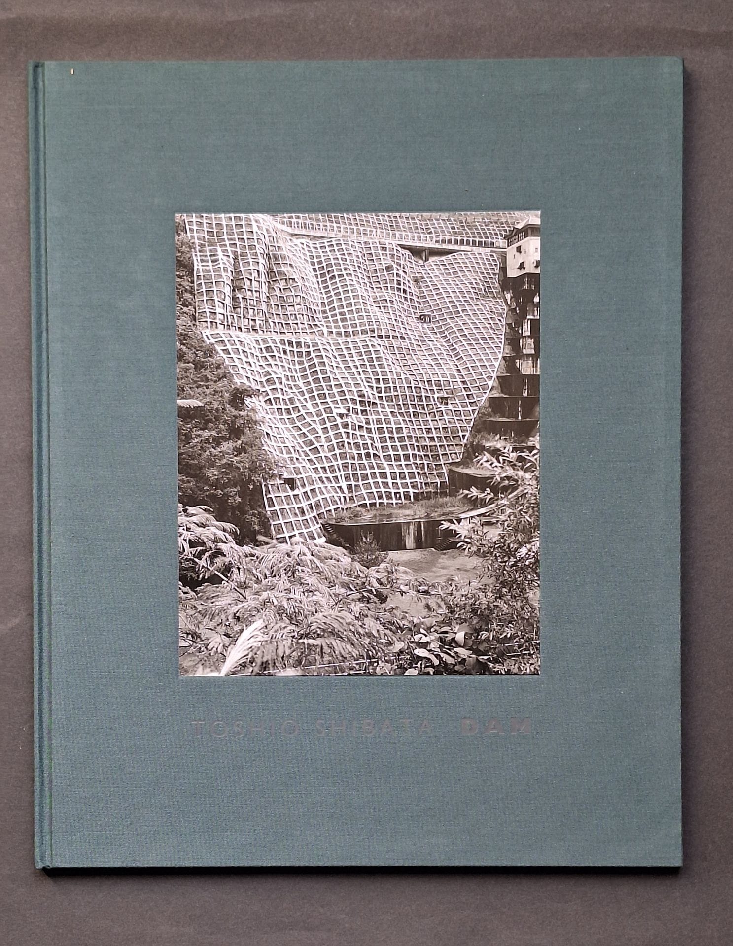 SHIBATA, TOSHIO (1949) [Signed]
Dam.
Nazraeli Press, Tucson, 2004.
In-folio (42.5 x 34.5 cm). Original edition, limited to 500 numbered copies signed by Toshio Shibata. 36 pp. 18 photographic plates reproduced in duotone. Cloth boards with laminated silver print, in publisher's titled gray slipcase.