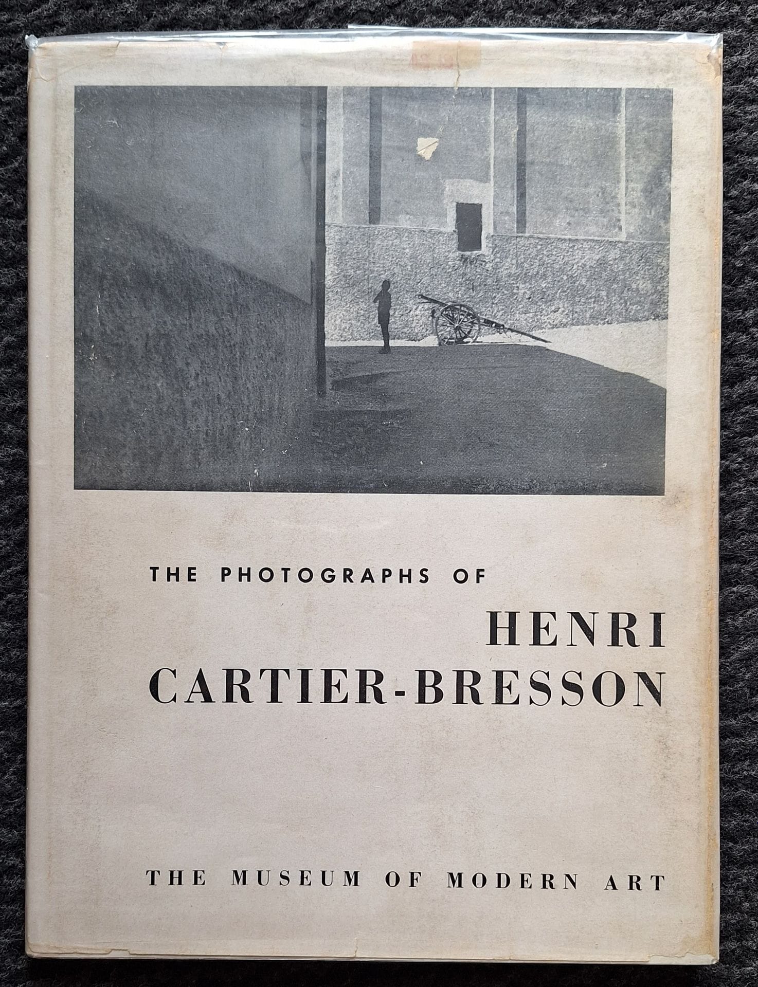 CARTIER-BRESSON, HENRI (1908-2004)
The photographs of Henri Cartier-Bresson.
The Museum of Modern Art, New-York, 1947.
 In-8 (25 x 19 cm). Édition originale reliée. 56 pages. 42 photographies. Textes de Lincoln Kirstein et Beaumont Newhall. Cartonnage d'éditeur avec titre en rouge sous sa rare jaquette d'origine conservée (une petite déchirure); ancien exemplaire de bibliothèque avec 3 discrets tampons dans l'ouvrage n'en affectant pas la qualité.