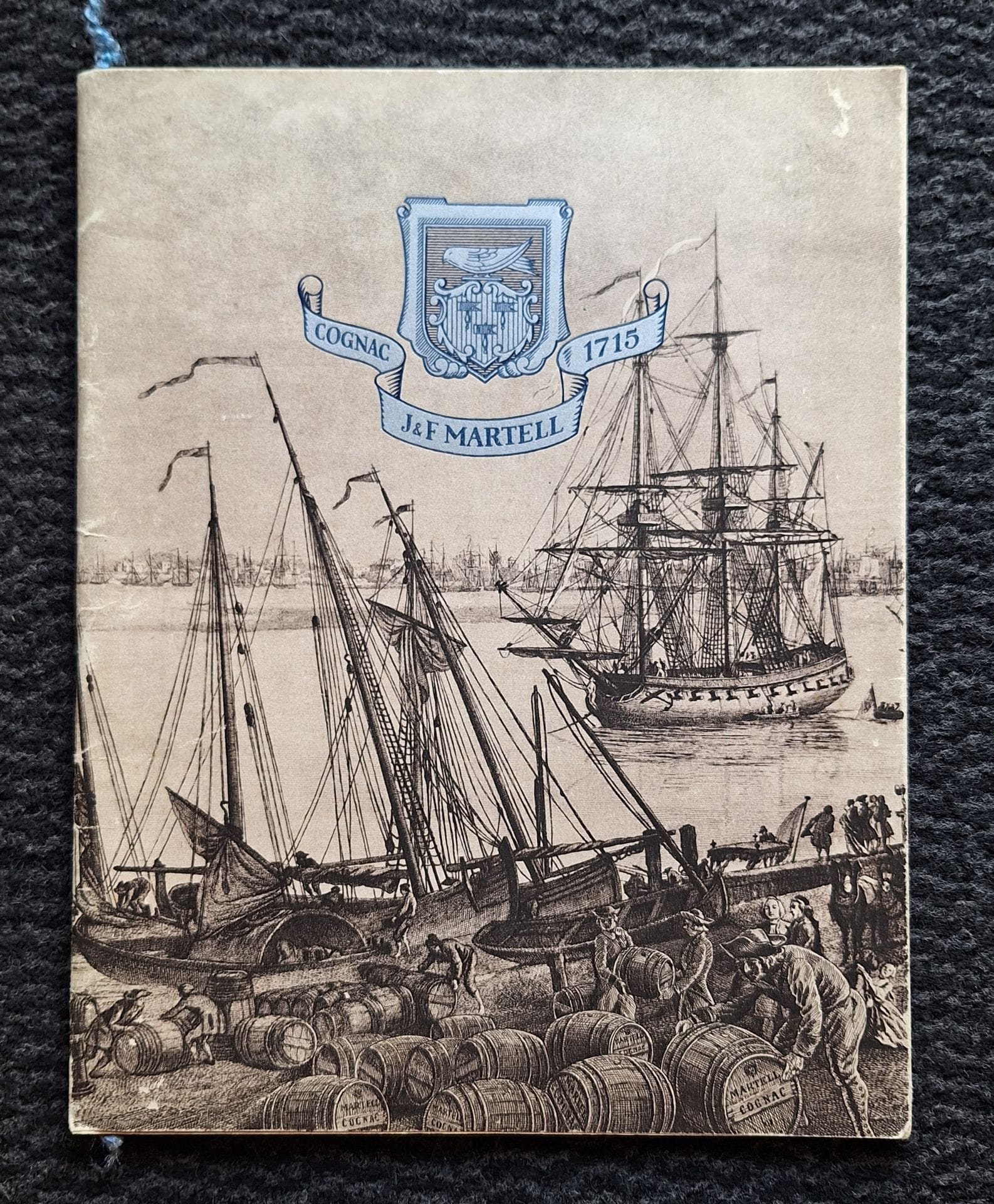 KOLLAR, FRANÇOIS (1904-1979)
Cognac J & F Martell 1715.
Ateliers A.B.C., s.d.
In-4 (27 x 22 cm). Édition originale. 28 pp. Photographies, superbement reproduites en héliogravure et en sépia, de François Kollar. Conception et réalisation de cette plaquette d'entreprise par les Ateliers A.B.C. Couverture souple sous jaquette illustrée à rabat. Sont glissés dans cette plaquette des documents sur Martell , ainsi qu'une petite plaquette 8 pages , avec des photographies de Draeger.