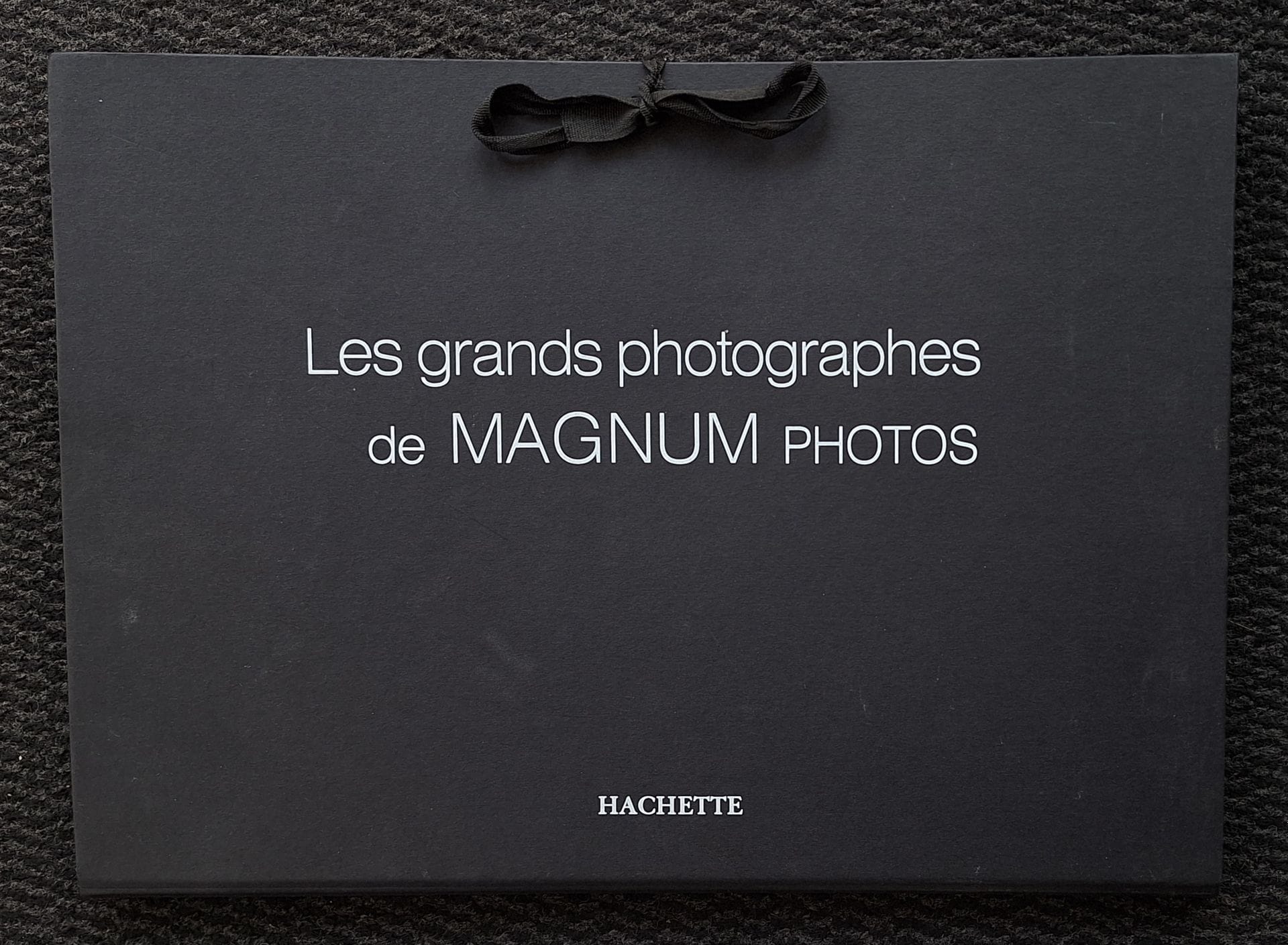 MAGNUM
Les grands photographes de Magnum Photos.
Édition Hachette, s.d.
Portfefeuille à lacet, titré en blanc, au format 30 x 43 cm contenant 60 affichettes du même format des meilleures photographies des photographes de l'Agence Magnum. Chaque affiche est légendée dans la marge inférieure et attribuée dans la marge supérieure. On trouve, entre autres: George Rodger, Bruce Davidson, Harry Gruyaert, Martin Parr, Inge Morath, Josef Koudelka, Ferdinando Scianna, Guy Le Querrec, W. Eugene Smith, Eve Arnold, Richard Kalvar, Stuart Franklin, Jean Gaumy, Carl de Keyzer, Leonard Freed, Wayne Miller, Peter Marlow, Gueorgui Pinkhassov, Susan Meiselas, Patrick Zachmann, Alex Webb, Paolo Pellegrin, Burt Glinn, Philippe Halsman, Ian Berry, John Vink, Bruce Gilden, Mark Power, Alex Majoli, Trent Park, Costa Manos, Jim Goldberg, Erich Lessing, Paul Fusco, Philip Jones Griffiths, Herbert List, Raghu Rai, Alec Soth, Hiroji Kubota, Cornell Capa, David Hurn, Henri Cartier-Bresson, David Seymour, Larry Towell, Martine Franck, Dennis Stock, René Burri, Abbas, Werner Bischof, Bruno Barbey, Raymond Depardon, Steve McCurry, Marc Riboud, Robert Capa, Elliott Erwitt, e.a.