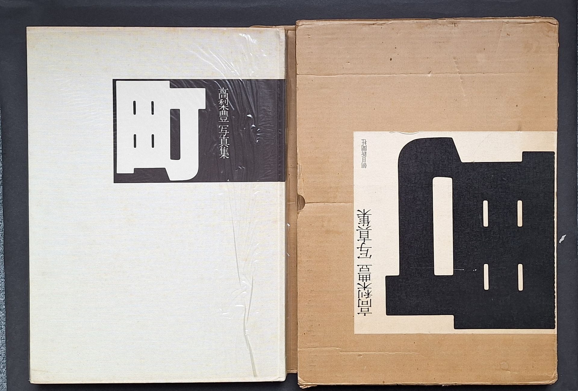 TAKANASHI, YUTAKA (1935)
Machi (Town). 
Asahi Shimbun, Tokyo, 1977. 
In-folio (42,5 x 30 cm). Édition originale. Photographies reproduites en couleurs à double page. Cartonnage d'éditeur en tissu blanc, sous jaquette transparente et carton d'éditeur titré.