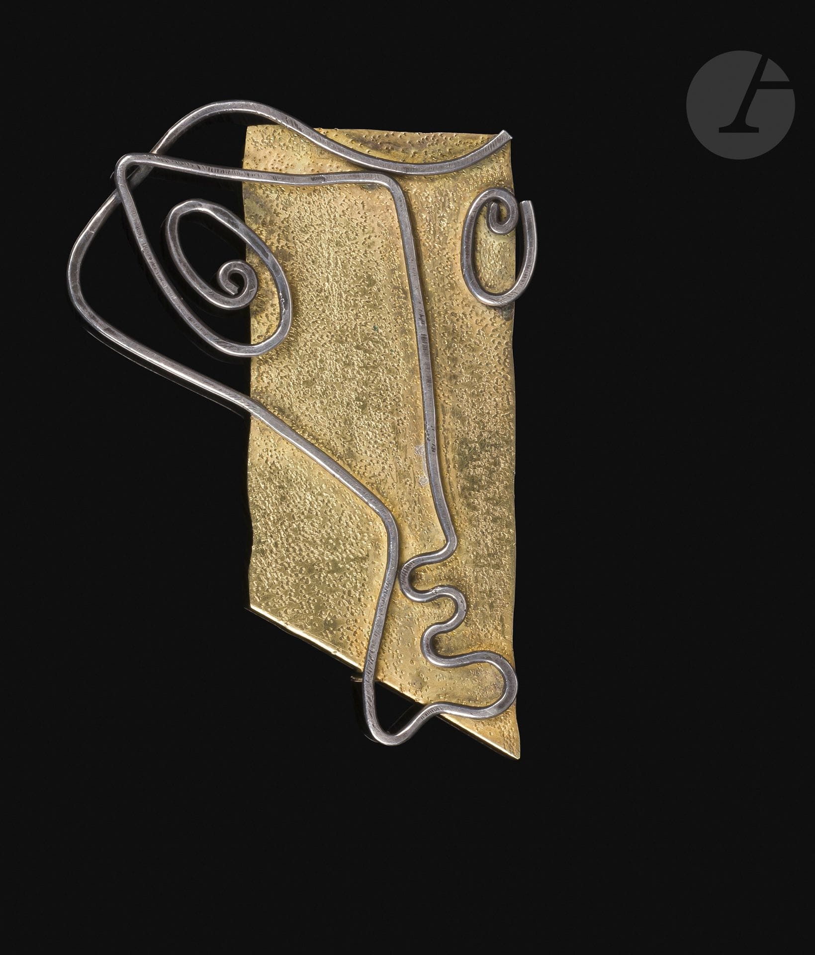 Asger JORN [danois] (1914-1973)
Visage cubiste [1937] 
Broche en or 750°/°° et argent 900°/°° martelé et ciselé.
Poinçons de garantie et poinçon d’orfèvre 
« A*C ».
6 x 4,3 cm
Poids : 14,8 grammes

Provenance : 
Collection particulière, Paris 6e.