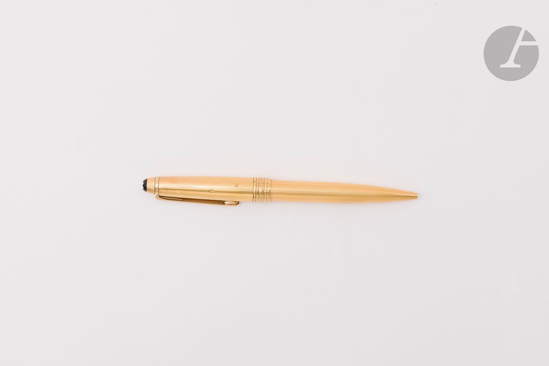MONTBLANC
Sytlo bille modèle "Meisterstuck" en métal doré guilloché, le capuchon orné d'une résine noir agrémenté du monogramme blanc de la maison. Signé (en l'état : usures, chocs)