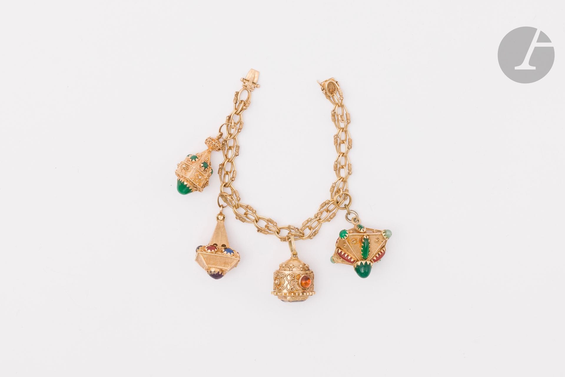 Bracelet en or 18K (750), retenant en pampilles 4 breloques en or 18K (750) chacune ornée de pierres de couleur ou de pâtes de verre coloré. Travail probablement italien des années 1960. Longueur : 19,5 cm environ. Poids brut : 68,6 g (anneau en métal, égrisures, chocs, manques de matière, pierres rapportées)