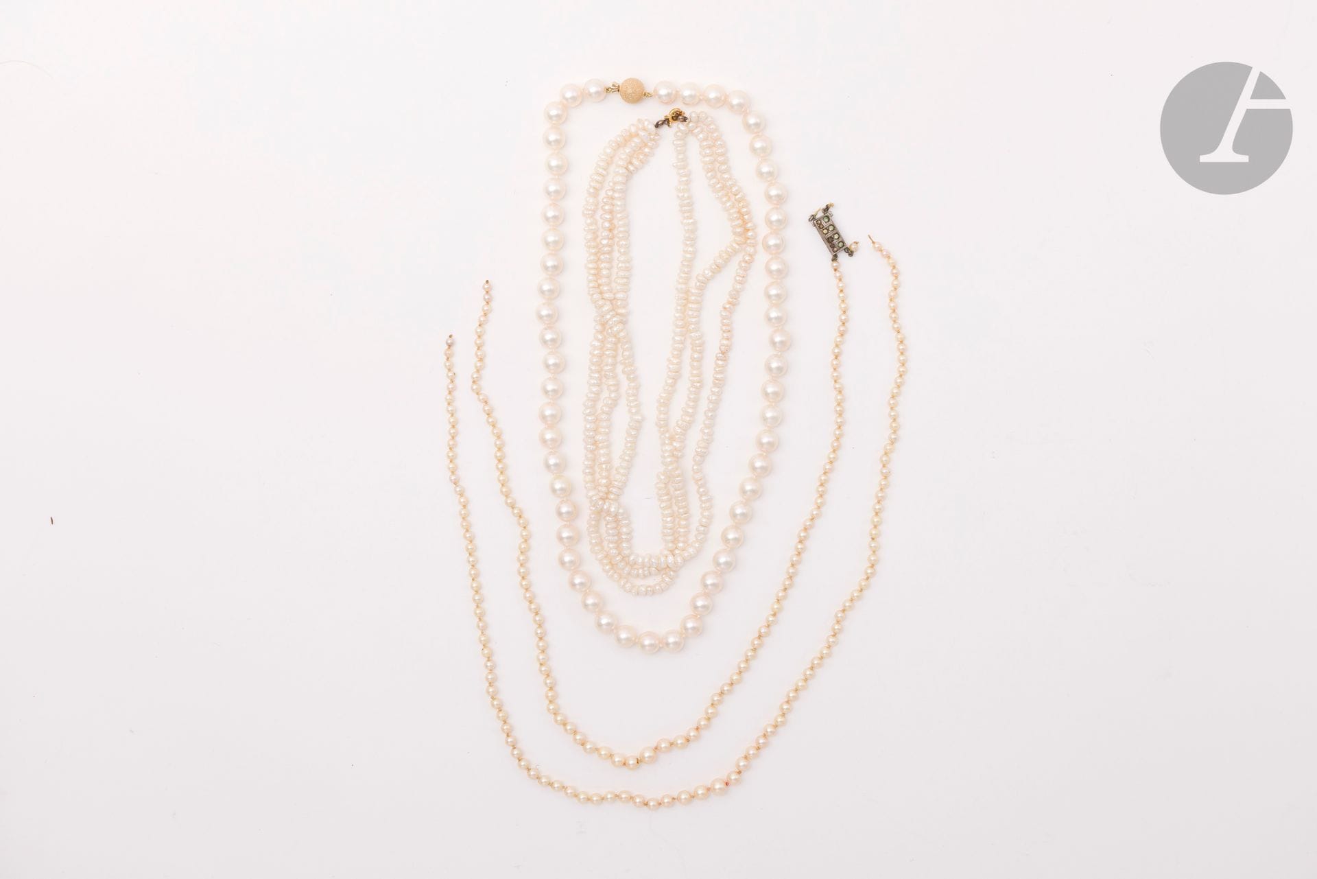 Suite de 3 colliers de perles de culture ou fantaisie, le 1er composé de deux rangs en chute, le fermoir en argent serti de pierres blanches d'imitation ; le 2ème agrémenté d'un fermoir sphérique en or 14K (585) martelé ; le 3ème comprenant 3 rangs, le fermoir en métal doré. Poids brut argent : 28,8 g (accident, à renfiler, aspérités). Poids brut or 14K : 59,4 g