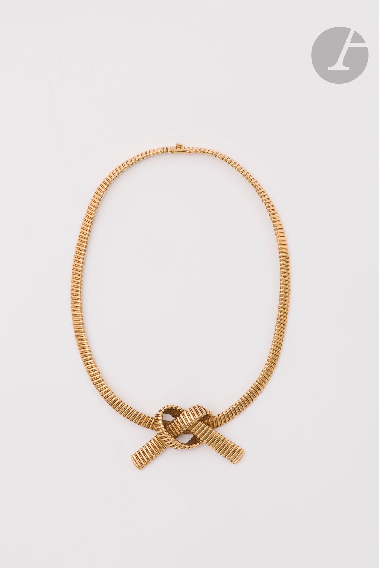 Collier ruban en or 18K (750) maillons tubogaz lisses et torsadés, terminé par un nœud. Travail français des années 1950. Longueur : 40 cm environ. Poids : 47,5 g
