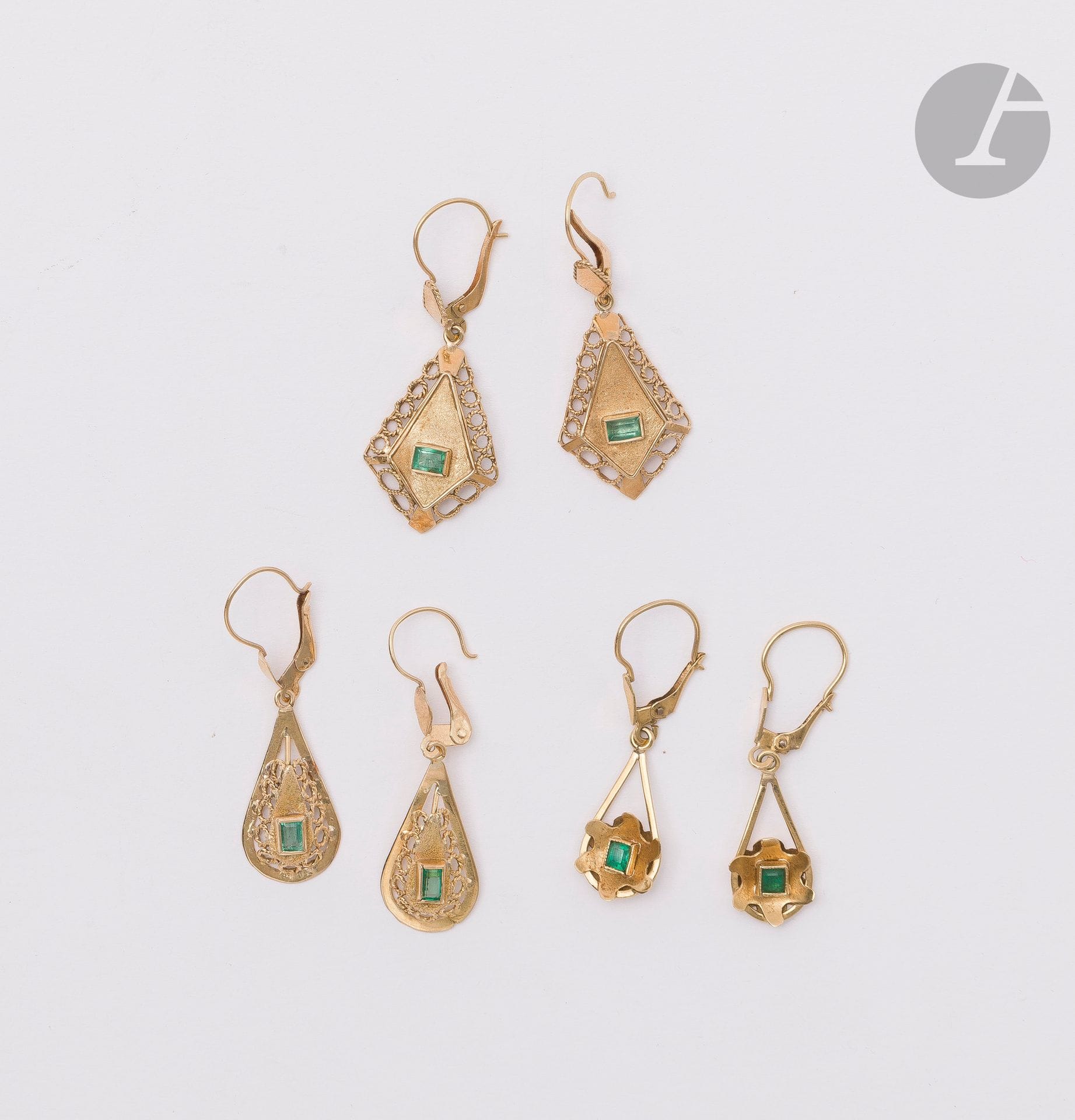 Three pairs of 18K (750) gold earrings, each holding a teardrop, diamond or star-shaped motif set with a rectangular or quadrangular emerald. Height: 3.6 to 3.9 cm approx. Gross weight: 7 g (accident, dent; pierced ear system)