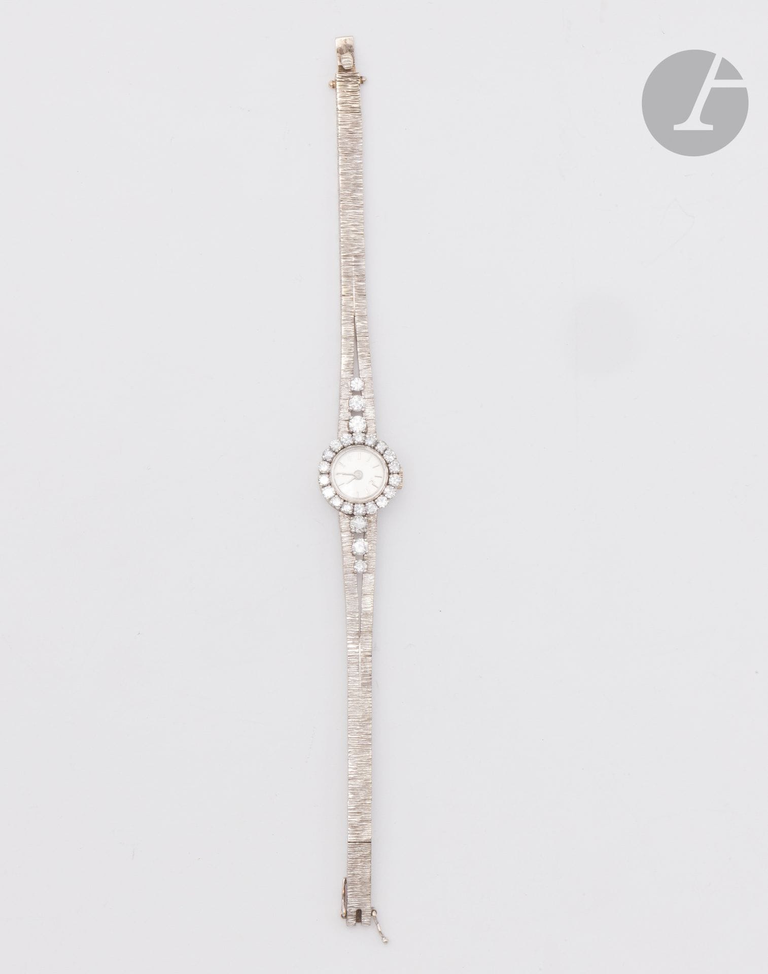 Montre de dame en or gris 18K (750) amati, cadran rond en or gris 18K et platine serti et épaulé de diamants ronds taille brillant, fond satiné, index bâtons, mouvement mécanique. Travail français. Longueur : 16,5 cm environ. Poids brut : 26,6 g (fonctionnement non garanti)