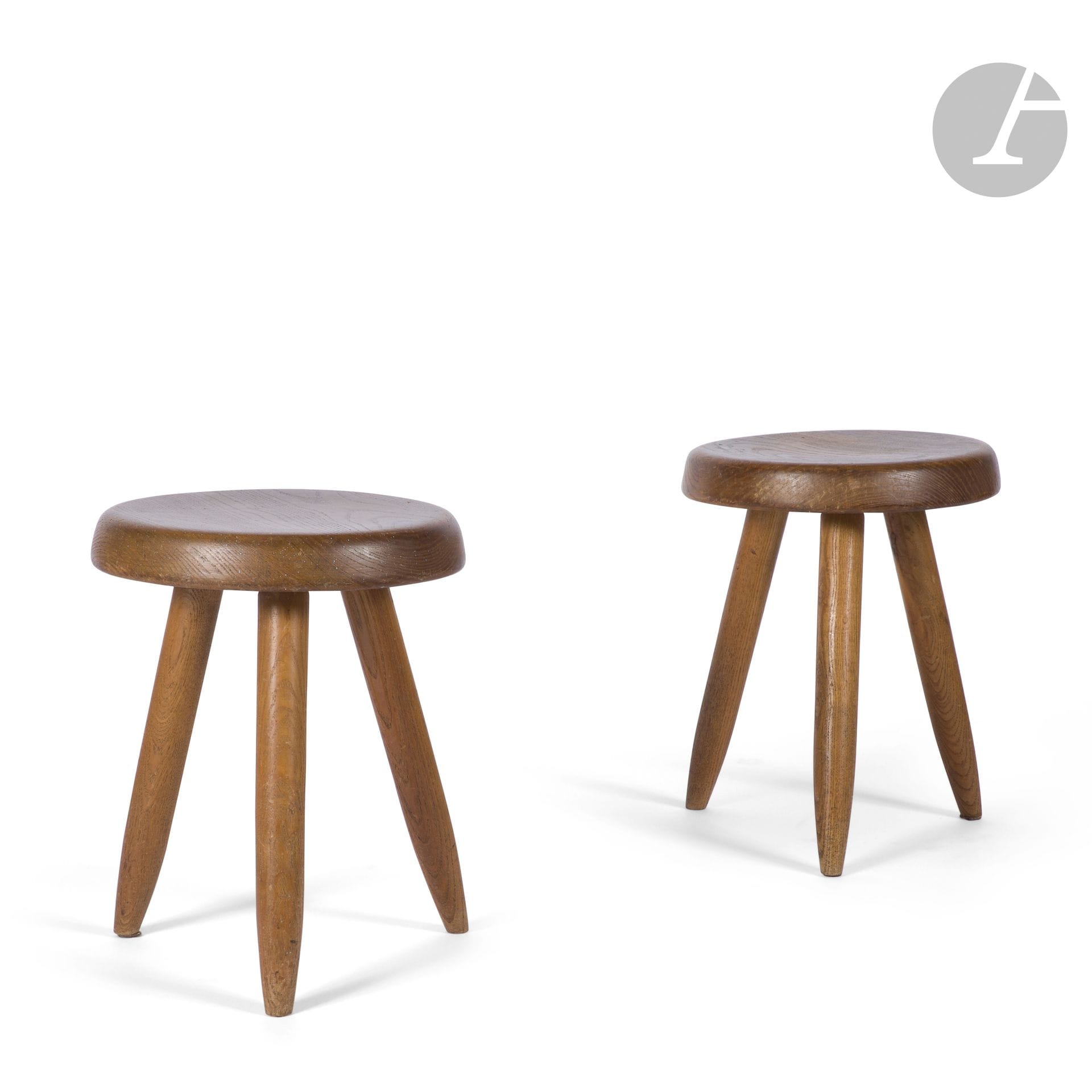 CHARLOTTE PERRIAND (1903-1999) - SUCCESSION X., MANTES-LA-VILLE
Berger, version haute, le modèle bas conçu en [1953-1954] pour la maison de Jacques Martin à Tokyo, œuvres acquises à la Galerie Steph Simon vers 1960
Paire de tabourets tripodes. 
Épreuve en frêne.
Les assisse en plein et légèrement creuses ; chacune à trois pieds terminés fuselés. 
État d’usage.
Hauteur : 40,5 cm – Diamètre : 32,5 cm

Provenance :
Succession X., Mantes-la-Ville. Œuvre acquise auprès de la Galerie Steph Simon vers 1960. Cette paire de tabourets faisait partie d’un aménagement complet conçu par le décorateurColas Guérin pour M. et Mme X., comprenant un ensemble mobilier de Charlotte Perriand (banquette Tokyo, nos deux tabourets Berger, table à gorges et suite de chaises) complété d’une applique de Serge Mouille et d’un meuble d’André Chetaille et présentés sous les numéros précédents et suivants de cette vacation.

Bibliographie :
- Aujourd’hui Art et Architecture – N° 7 de mars 1956. Modèle identique reproduit page 81.
- Jacques Barsac - Charlotte Perriand – L’œuvre complète – Volume 2. 1940-1955 – Édition Archives Charlotte Perriand/Norma, Paris, 2013. Modèle identique, noirci, reproduit page 458.
- Jacques Barsac - Charlotte Perriand – L’œuvre complète – Volume 3. 1956-1968 – Édition Archives Charlotte Perriand/Norma, Paris, 2017. Modèles identiques, dans des variantes d’essence, reproduits pages 14 et 15.