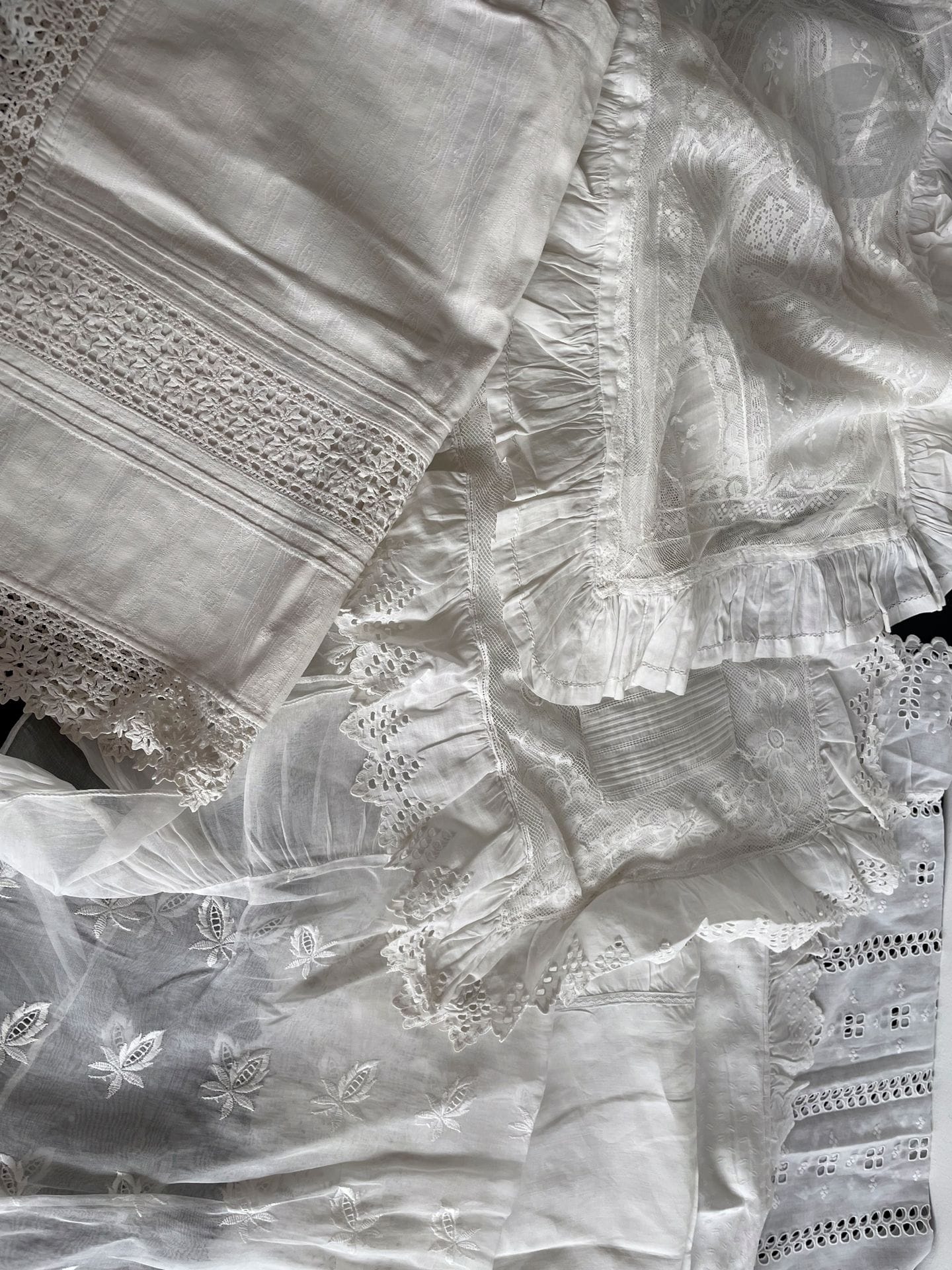Fifteen cradle or baby carriage pillows in linen, damask linen, filet embroidery, broderie anglaise and lace, circa 1900.