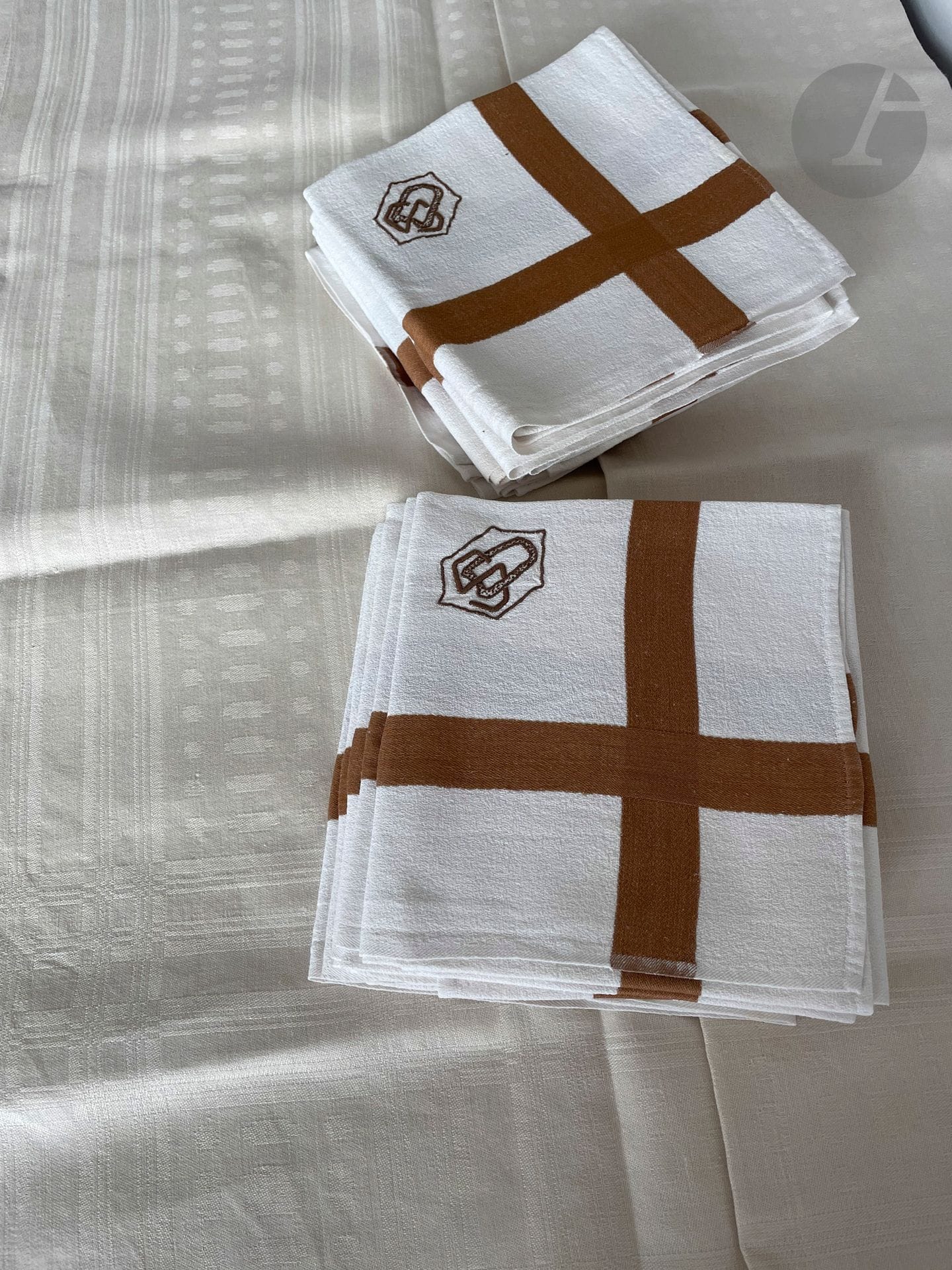 Lot de 12 serviettes en lin fantaisie, Alsace, XXe siècle. Lin granité à liteau brun et monogramme " SD " en lettres Art-Déco et nappe en damas de lin miel à décor de pastilles et motifs géométriques (150 x 200 cm)