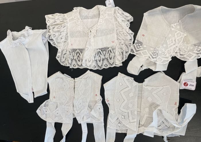 Cinq collerettes du costume alsacien pour fillettes, Alsace, XIXe siècle Forme plastron sans collerette en lin amidonné ourlé de large volant de dentelle aux fuseaux ou crochet sur le devant, marqués des initiales de leur propriétaire en rouge.